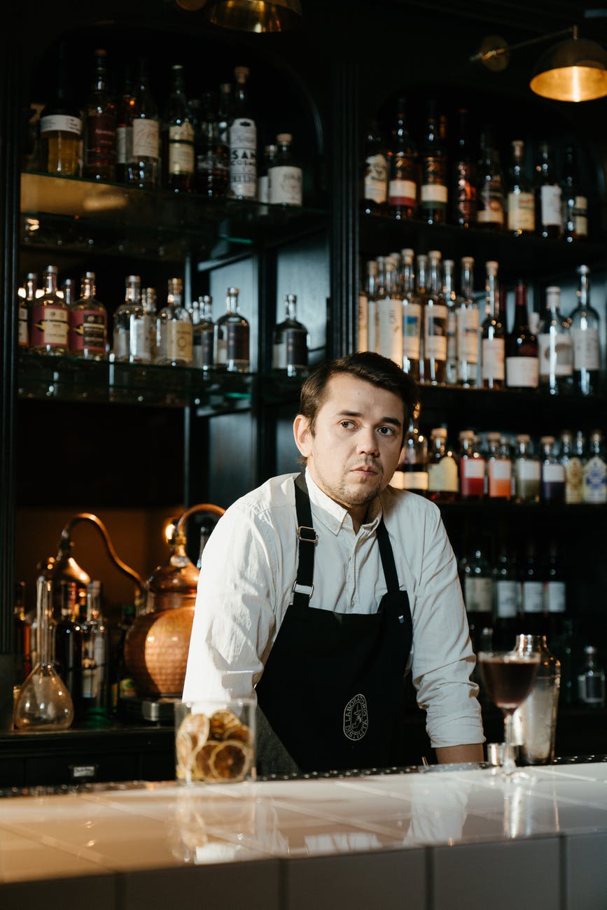 A frustrated bartender serving at the bar. | Photo: Pexels