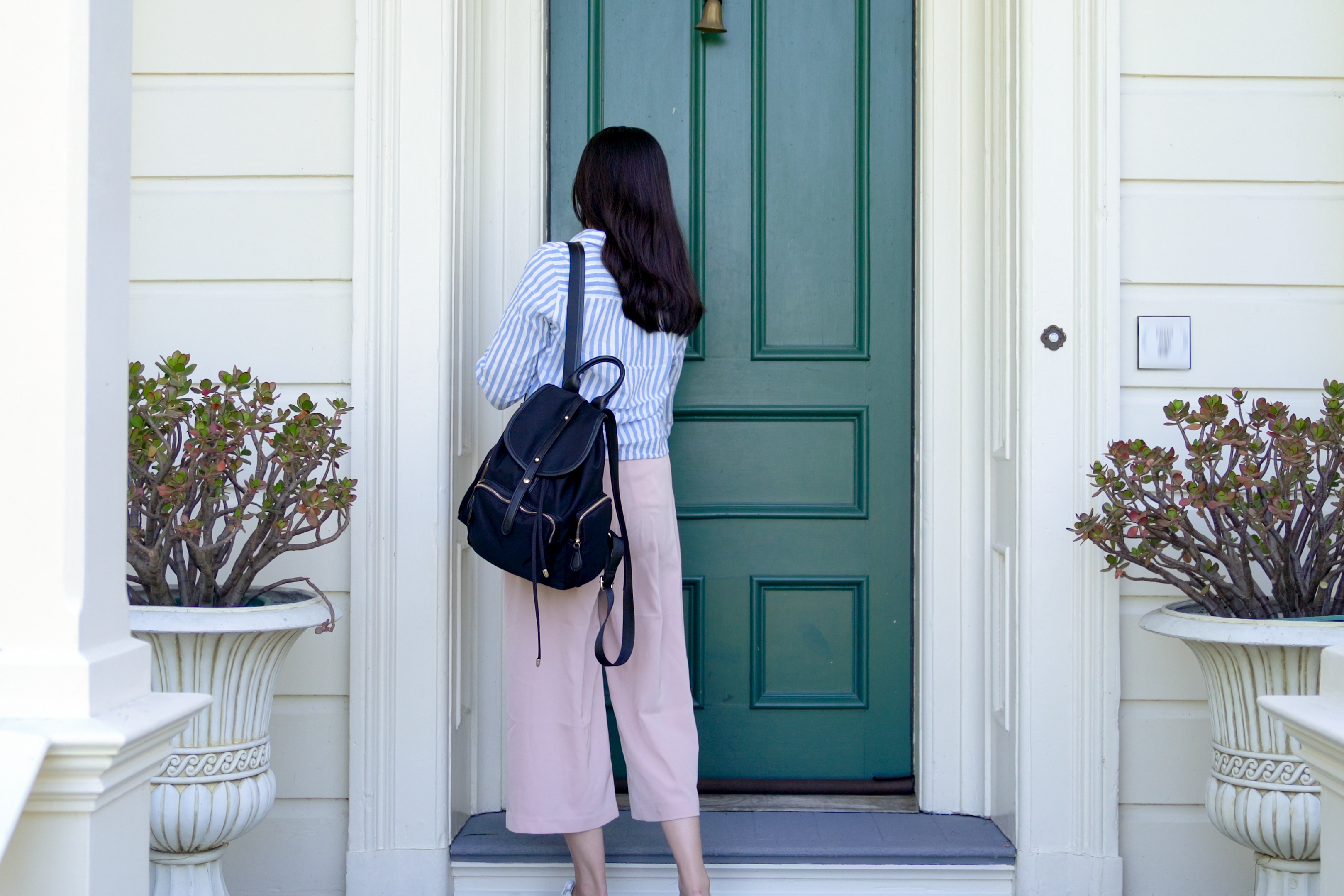 A rear view of a college student carrying a backpack back home | Source: Shutterstock