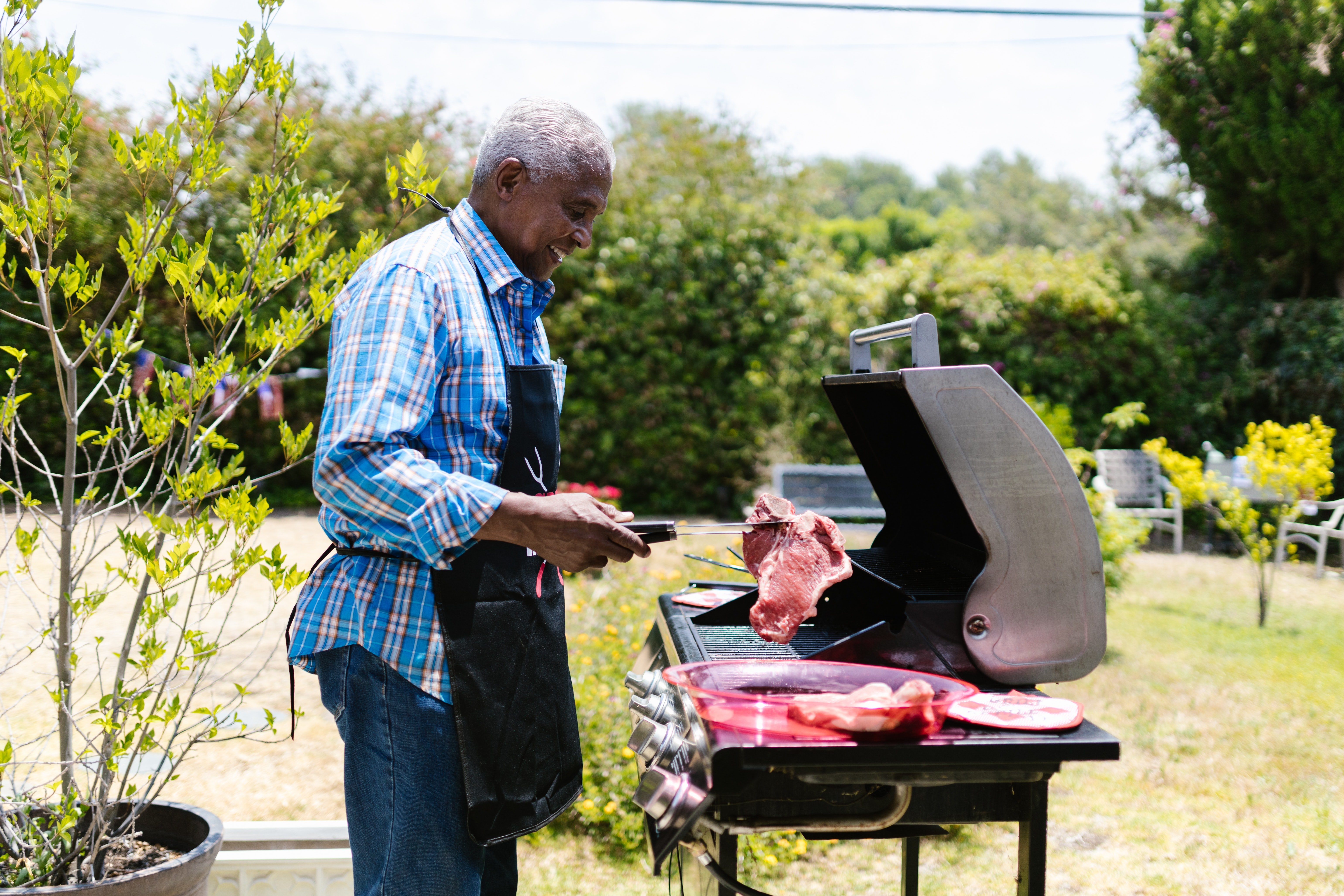 A happy man grilling meat | Photo: Pexels