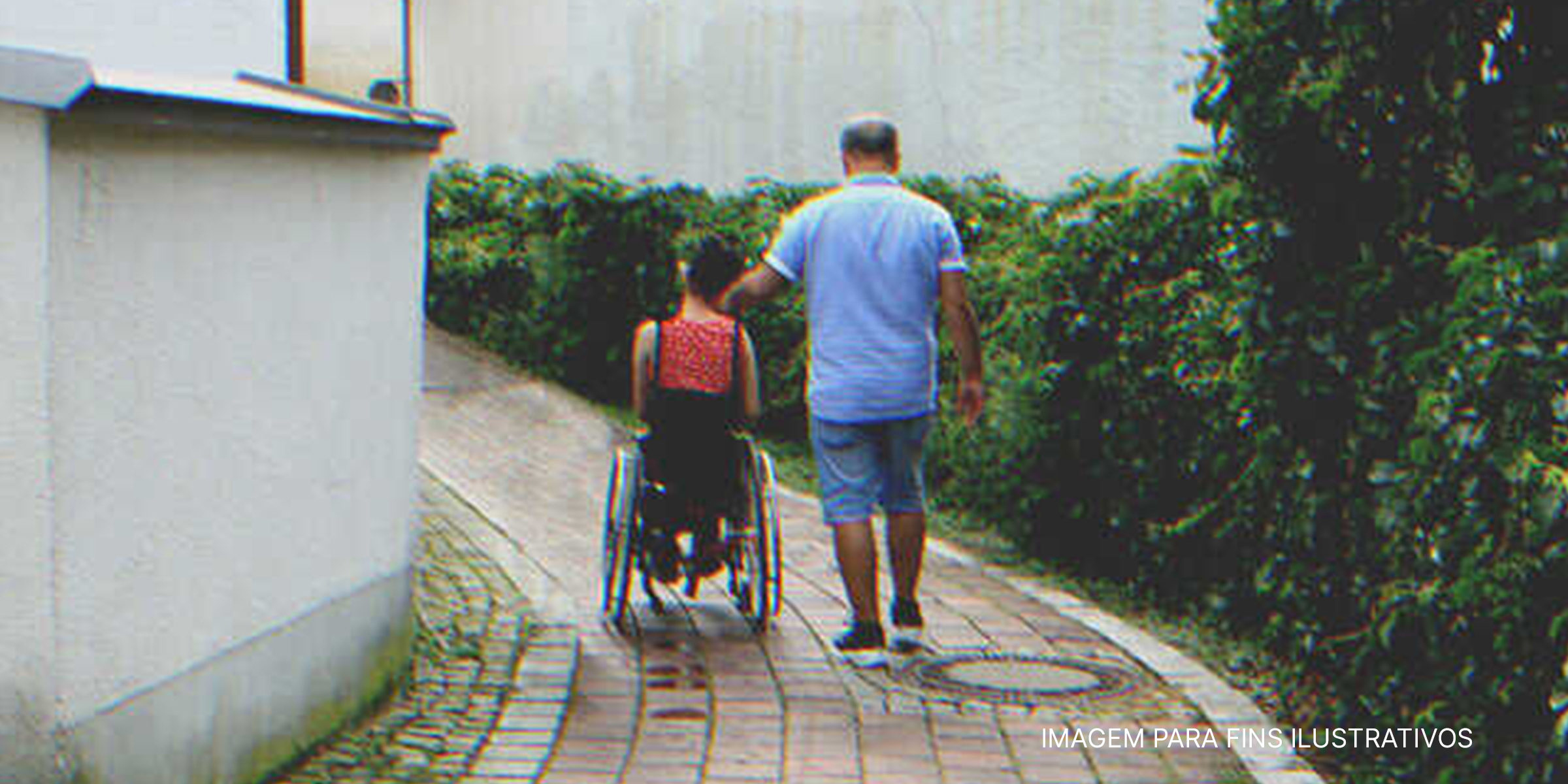 Homem caminha ao lado de jovem mulher em cadeira de rodas | Foto: Shutterstock