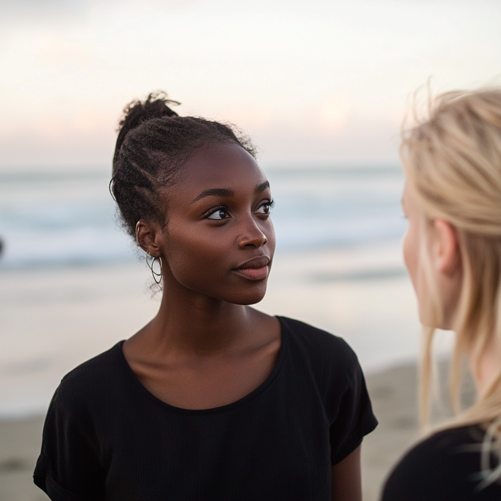 Two women talking at the beach | Source: Midjourney