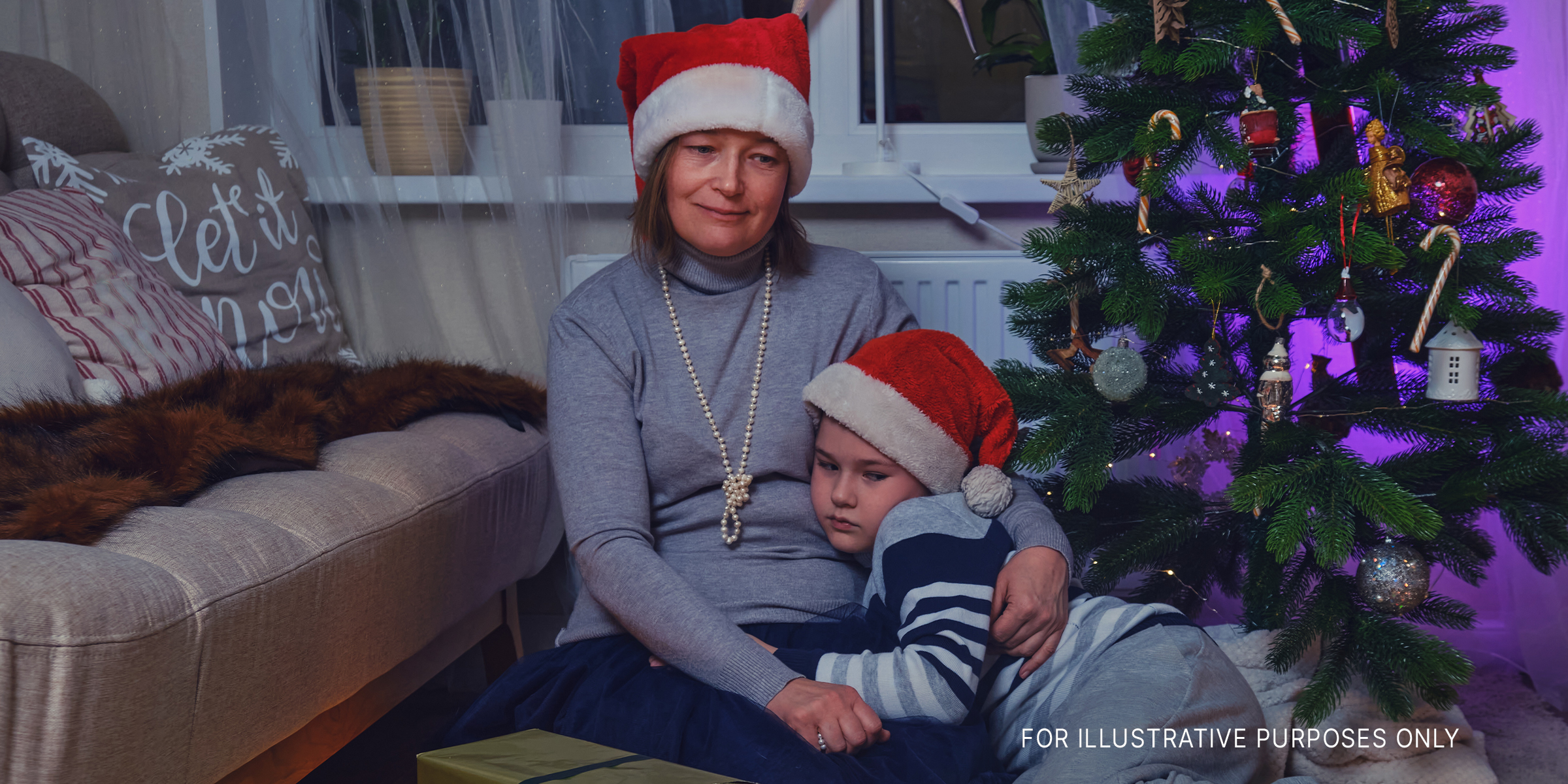 Sad mother and son sitting near the Christmas tree | Source: Getty Images