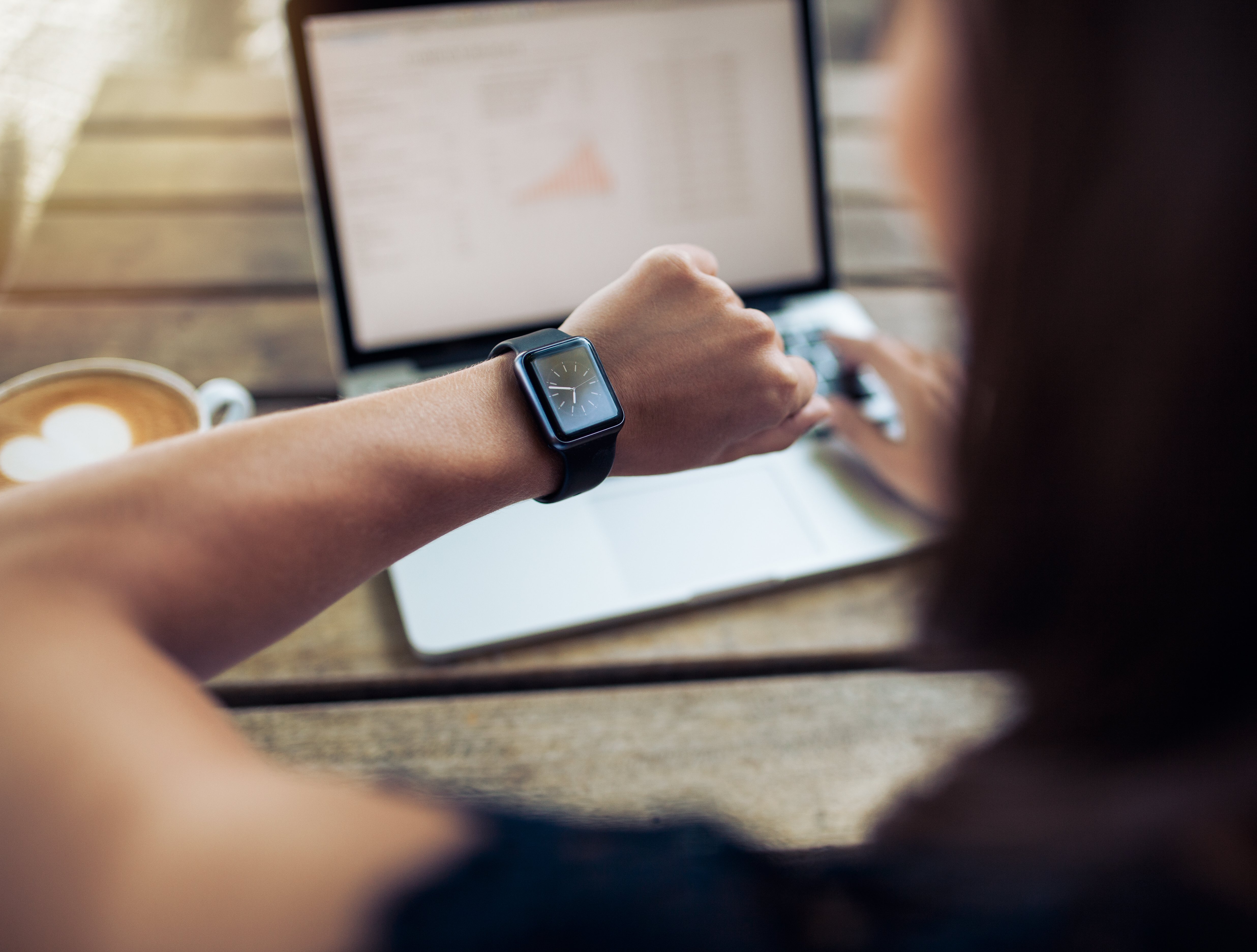 Mujer mira su reloj mientras trabaja | Foto: Shutterstock