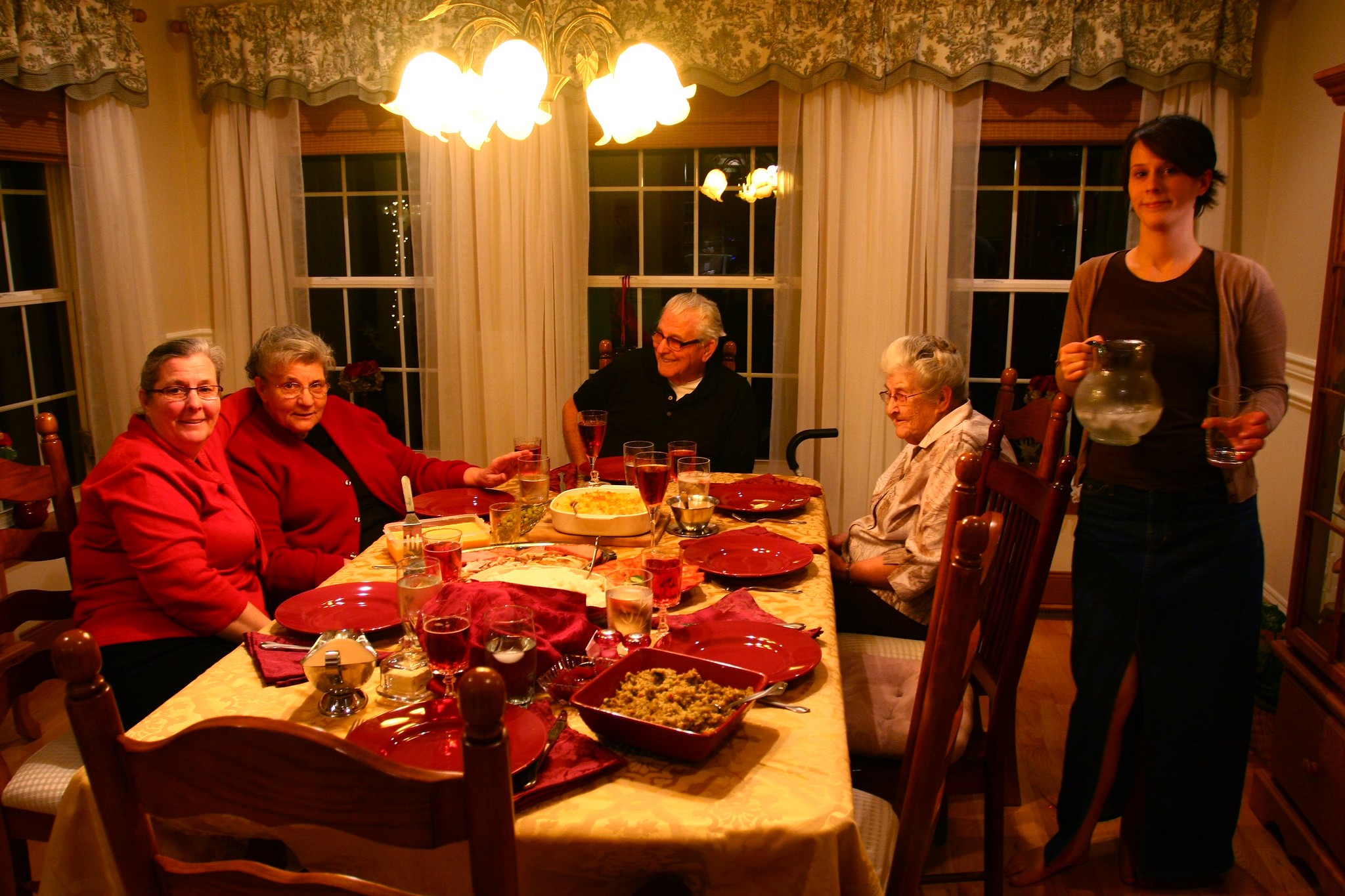 A woman server standing close to a family gathered for Christmas dinner | Source: Flickr