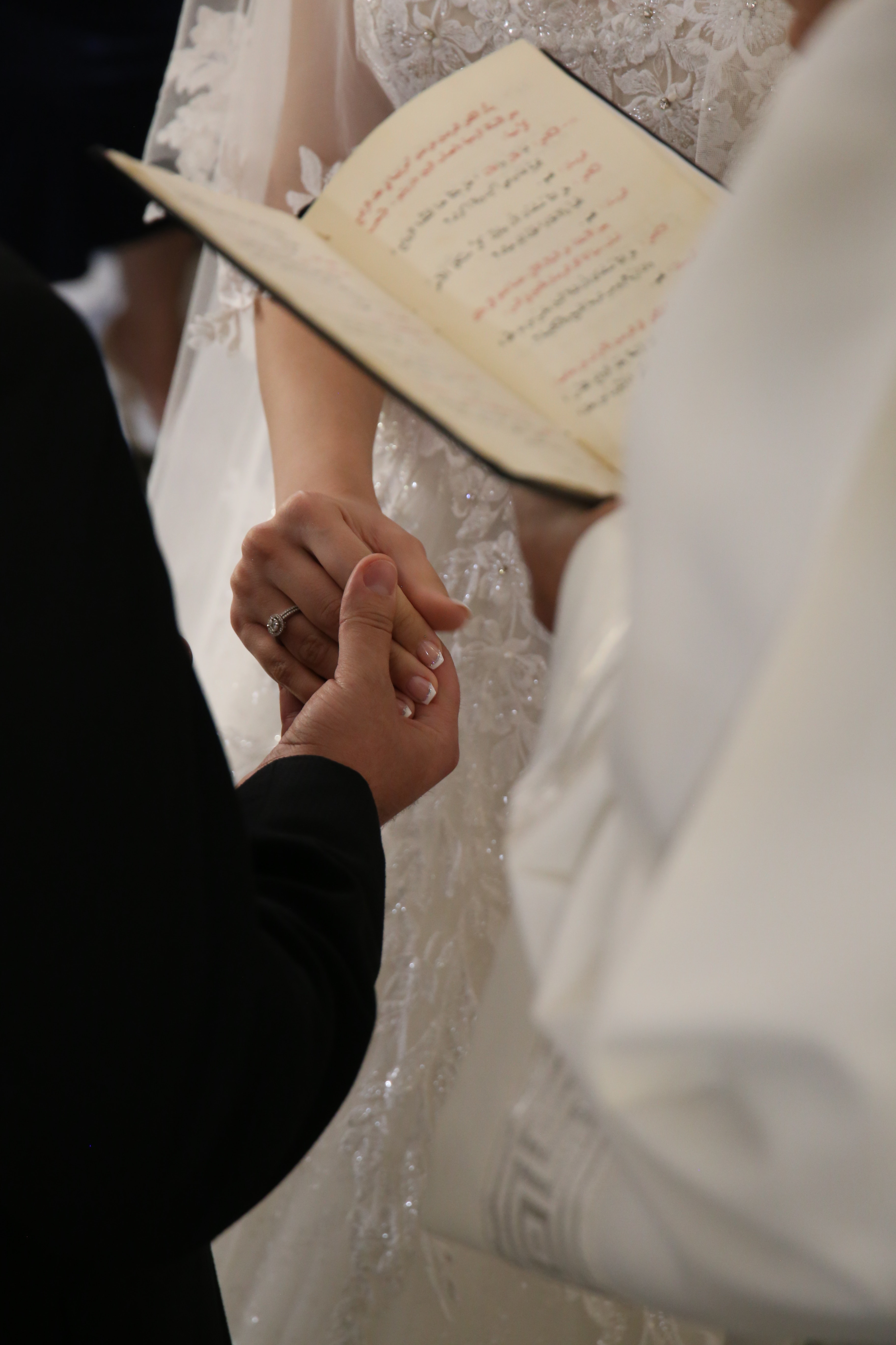 Newlyweds holding hands on wedding ceremony | Source: Pexels
