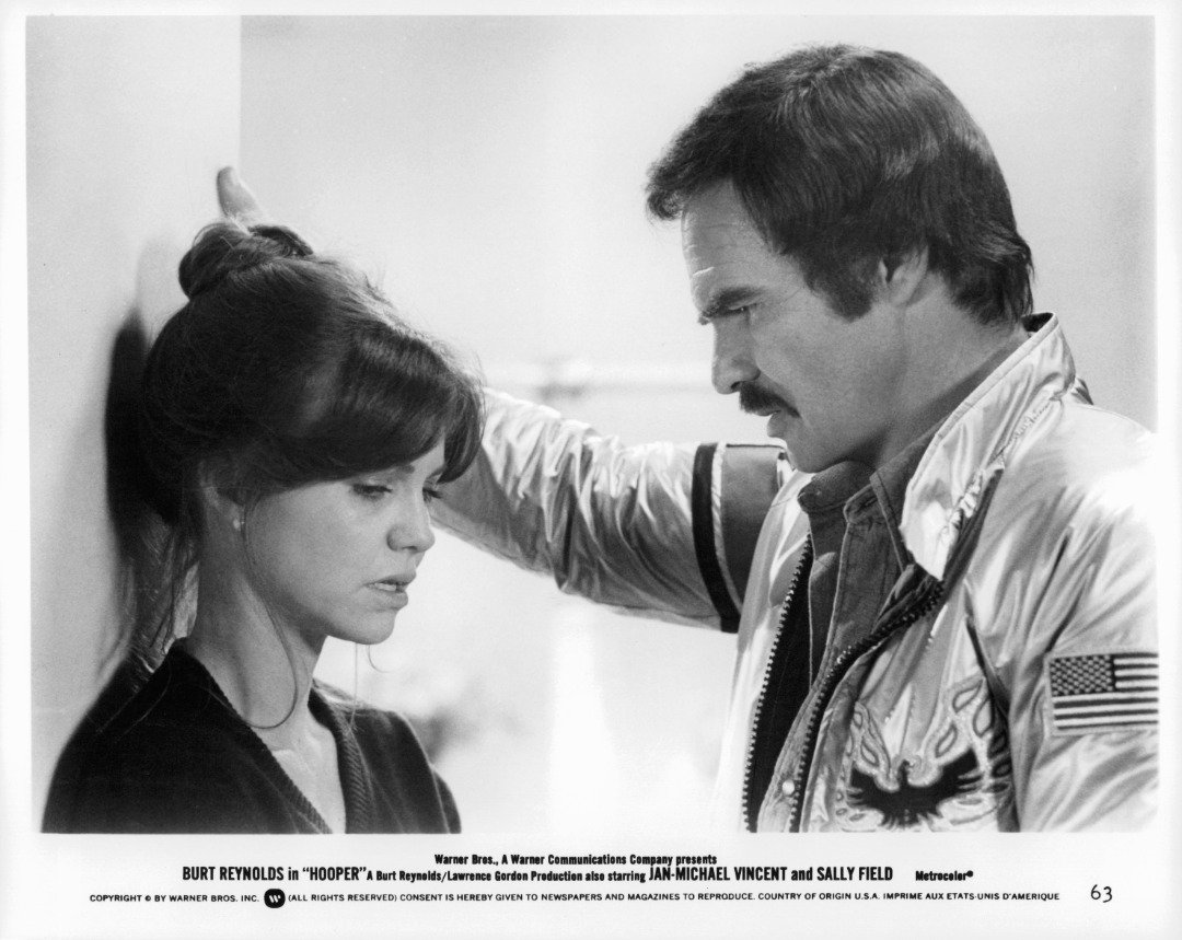 Sally Field talks while Burt Reynolds listens in a scene from the film 'Hooper', 1978. | Source: Getty Images