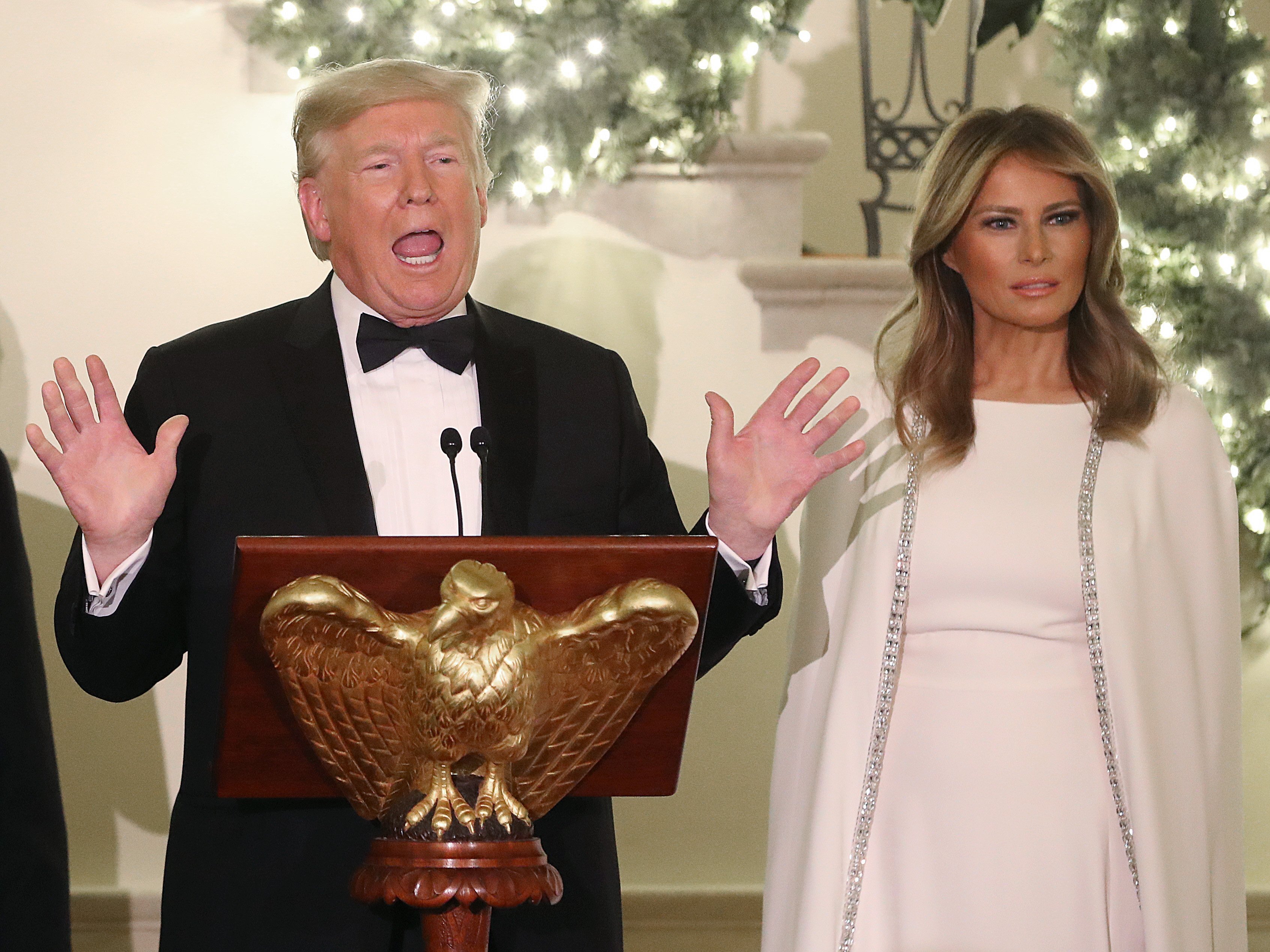 U.S. President Donald Trump speaks as first lady Melania Trump looks during a Congressional Ball in the Grand Foyer of the White House on December 12, 2019 |Photo: Getty Images