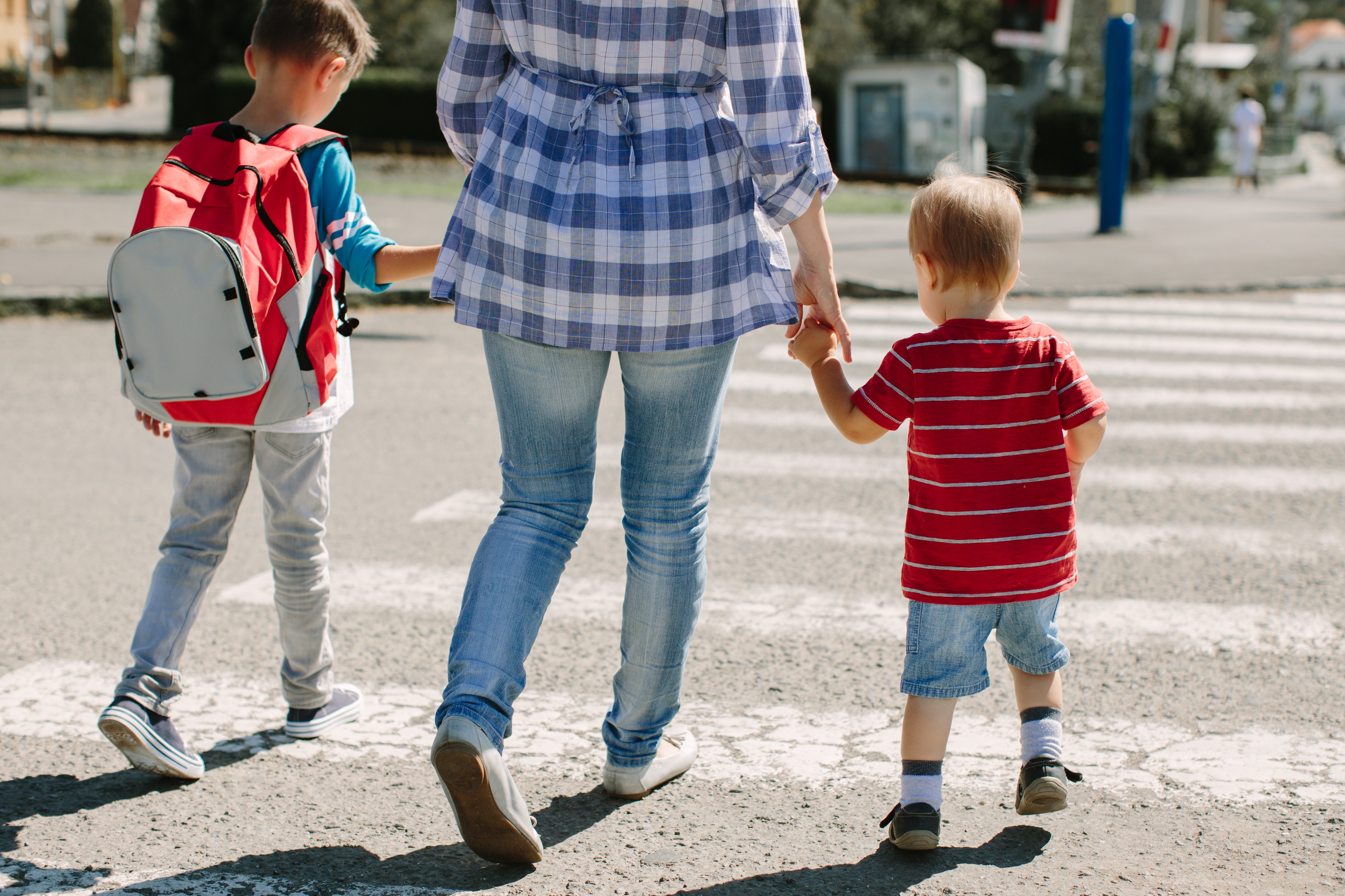 A mother crossing the road with her children. | Source: Shutterstock 