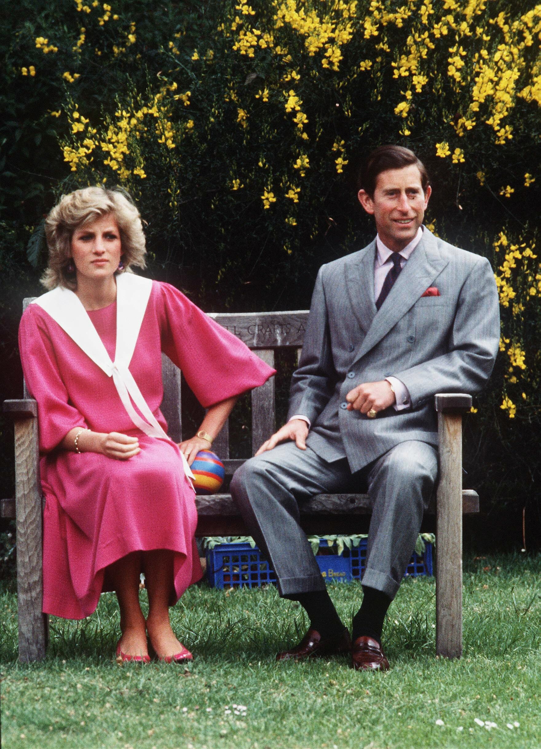 Prinz Charles und Prinzessin Diana im sechsten Monat schwanger mit Prinz Harry sitzen auf einer Holzbank während eines Fototermins im Garten ihres Hauses im Kensington Palace am 12. Juni 1984 in London, Vereinigtes Königreich. | Quelle: Getty Images