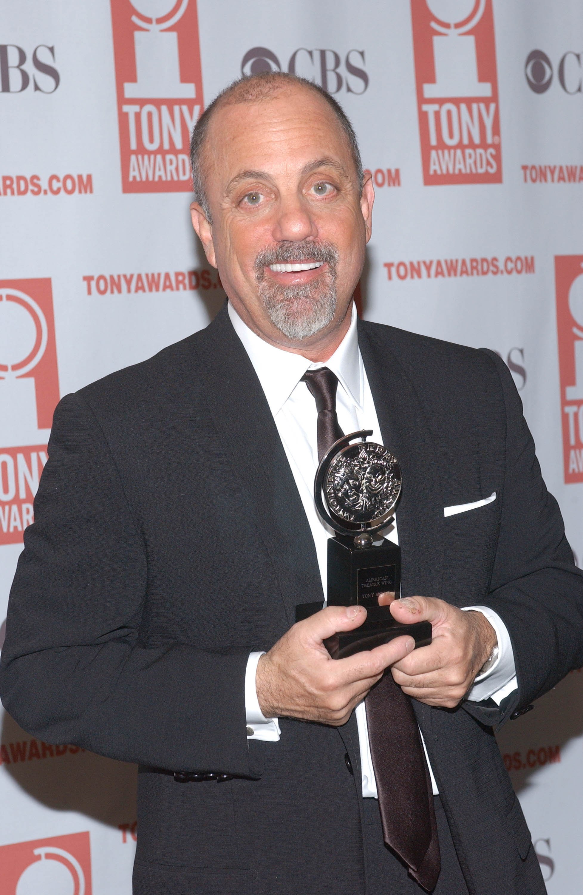 Rock and pop singer Billy Joel holding his award for winner of Best Orchestrations, "Movin Out"  at the Tony Awards in 2003. / Source: Getty Images