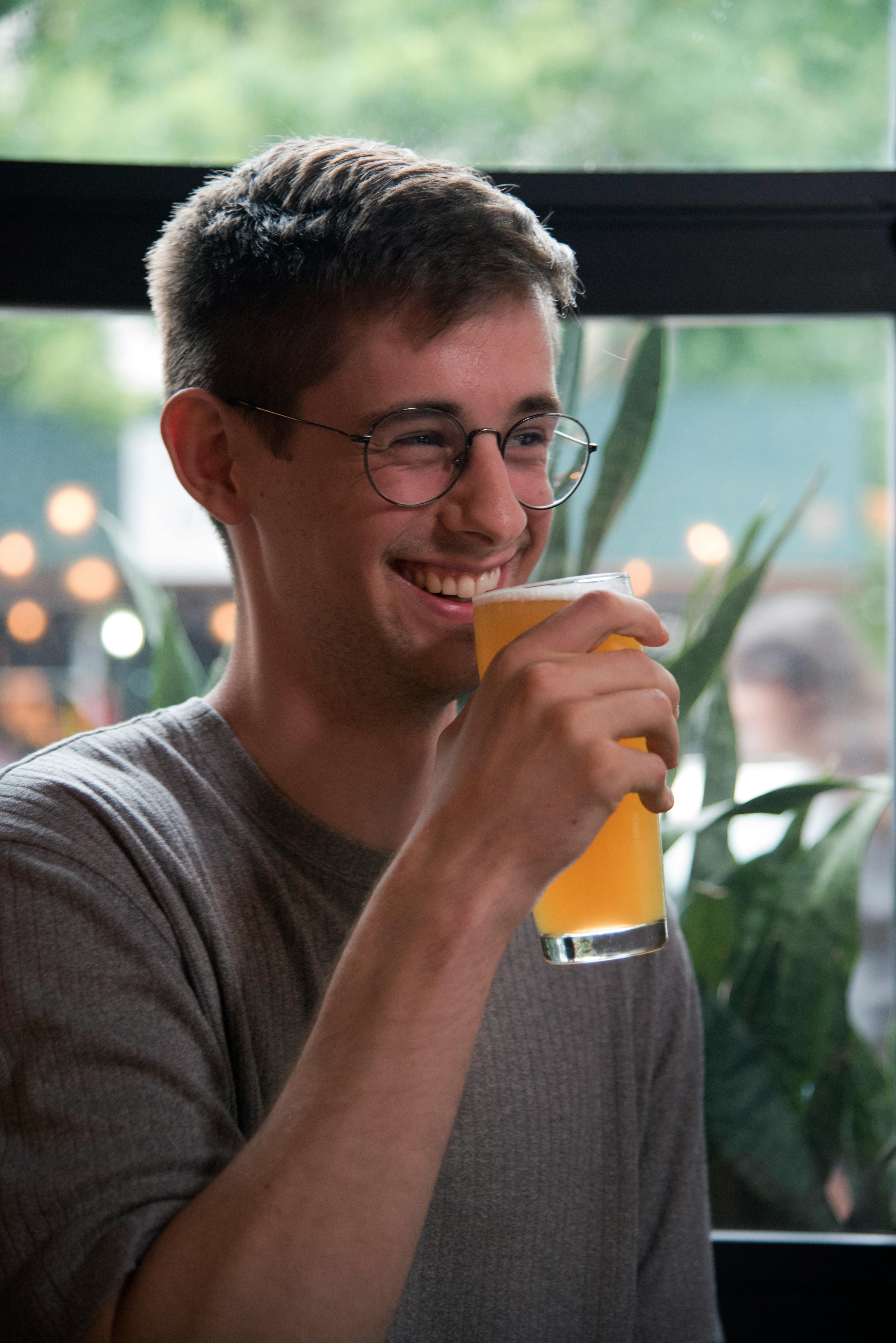 A man having a beverage while laughing | Source: Pexels