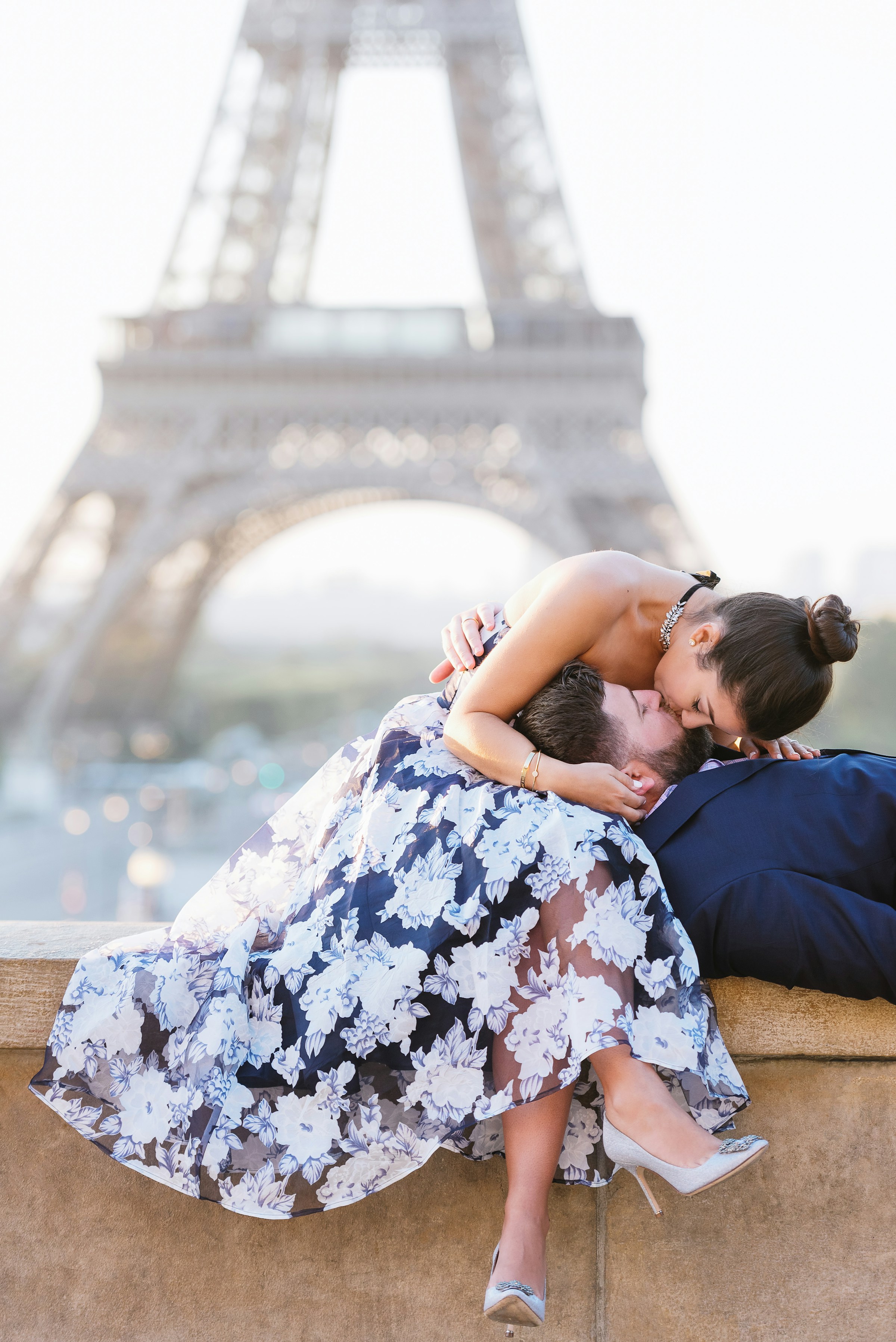 A couple kissing on a ledge in front of the Eiffel Tower in Paris | Source: Unsplash