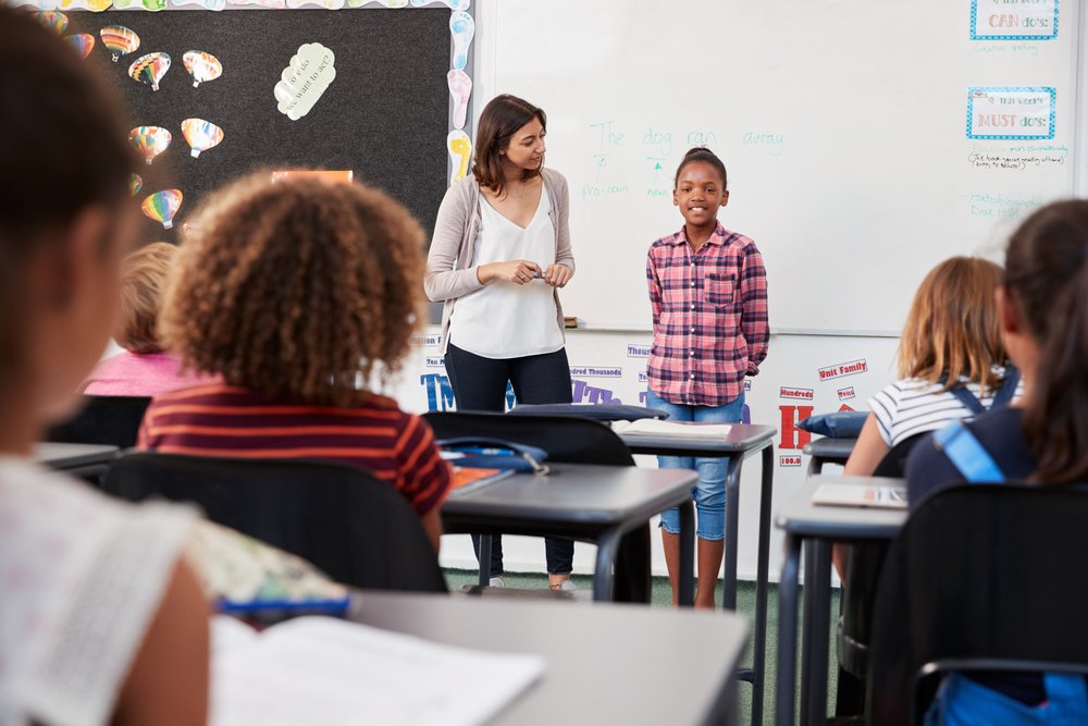 A teacher and a pupil in front of an elementary school class. | Photo: Shutterstock