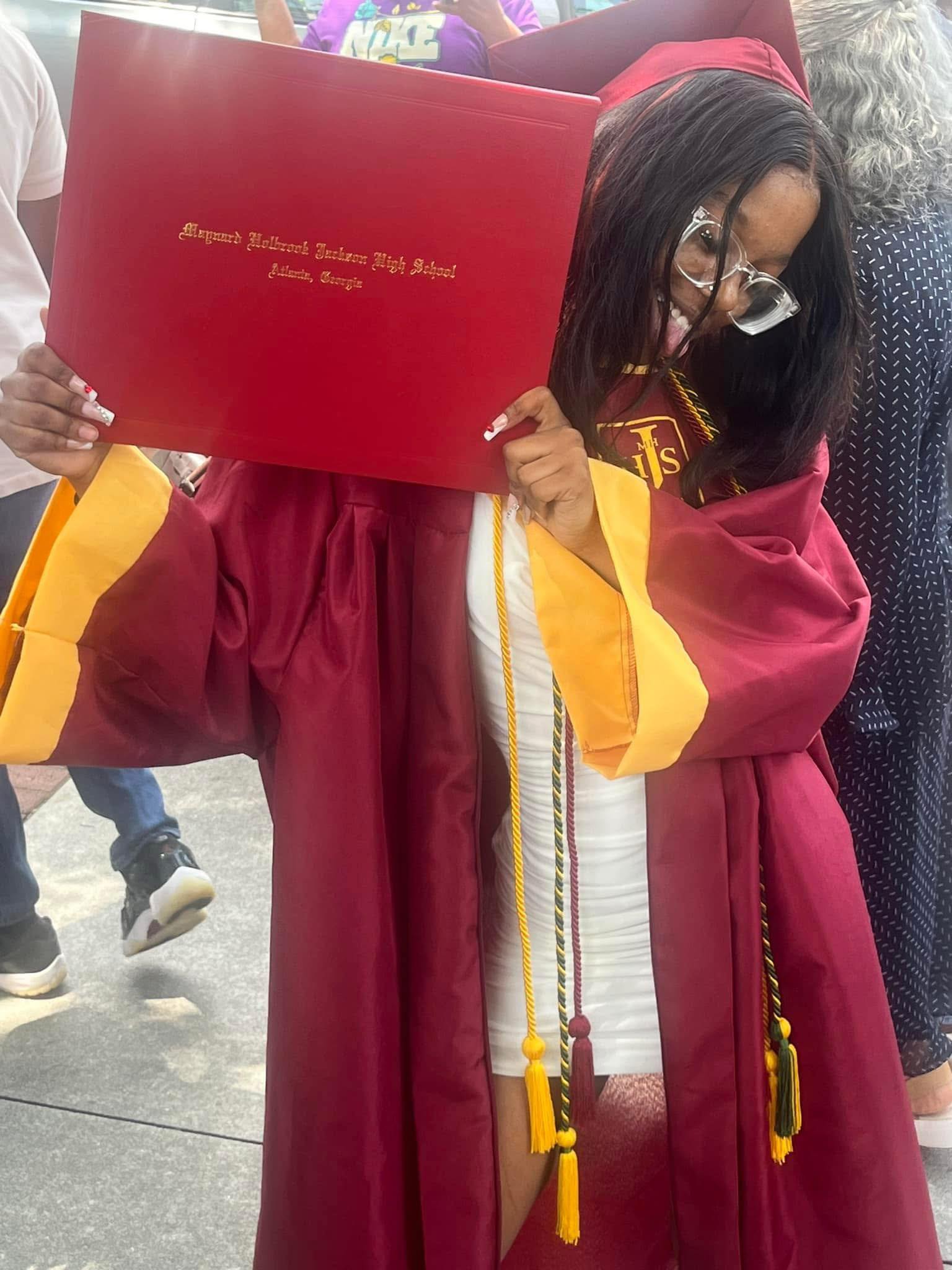 Jaylah Donald in her graduation cap, holding up her degree, from a post dated March 20, 2025 | Source: Facebook/Genette Anderson