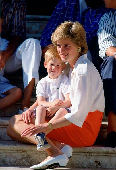 Diana, Prinzessin von Wales, sitzt auf den Stufen des Marivent-Palastes mit ihrem Sohn, Prinz Harry, auf ihrem Schoß bei einem Fototermin während ihres Sommerurlaubs | Quelle: Getty Images