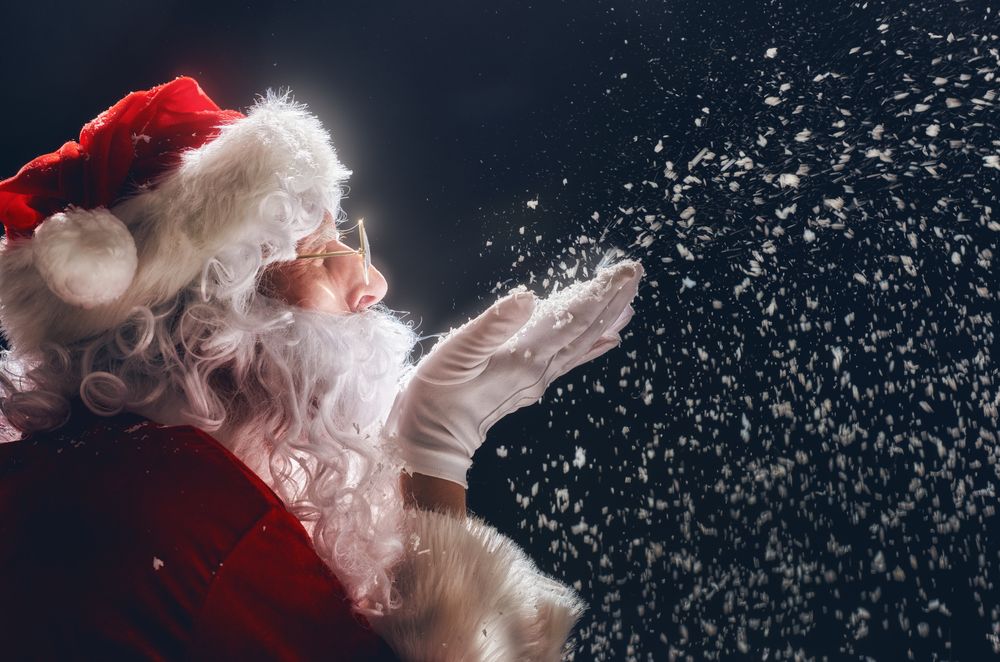 Santa Claus blowing snow into the air. | Source: Shutterstock