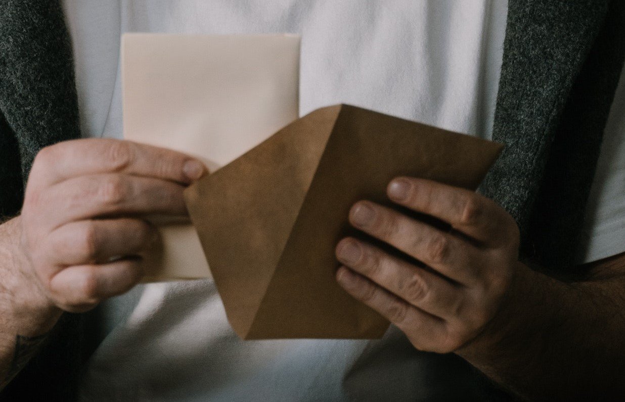 A person taking out a letter from an envelope | Source: Pexels