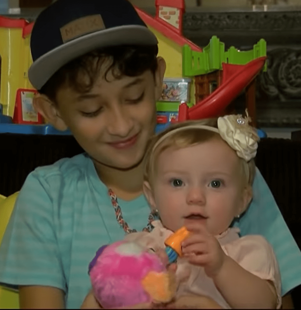 Jayden Fontenot carrying his baby sister while she was playing with her toys.| Source: youtube.com/KPRC 2 Click2Houston 