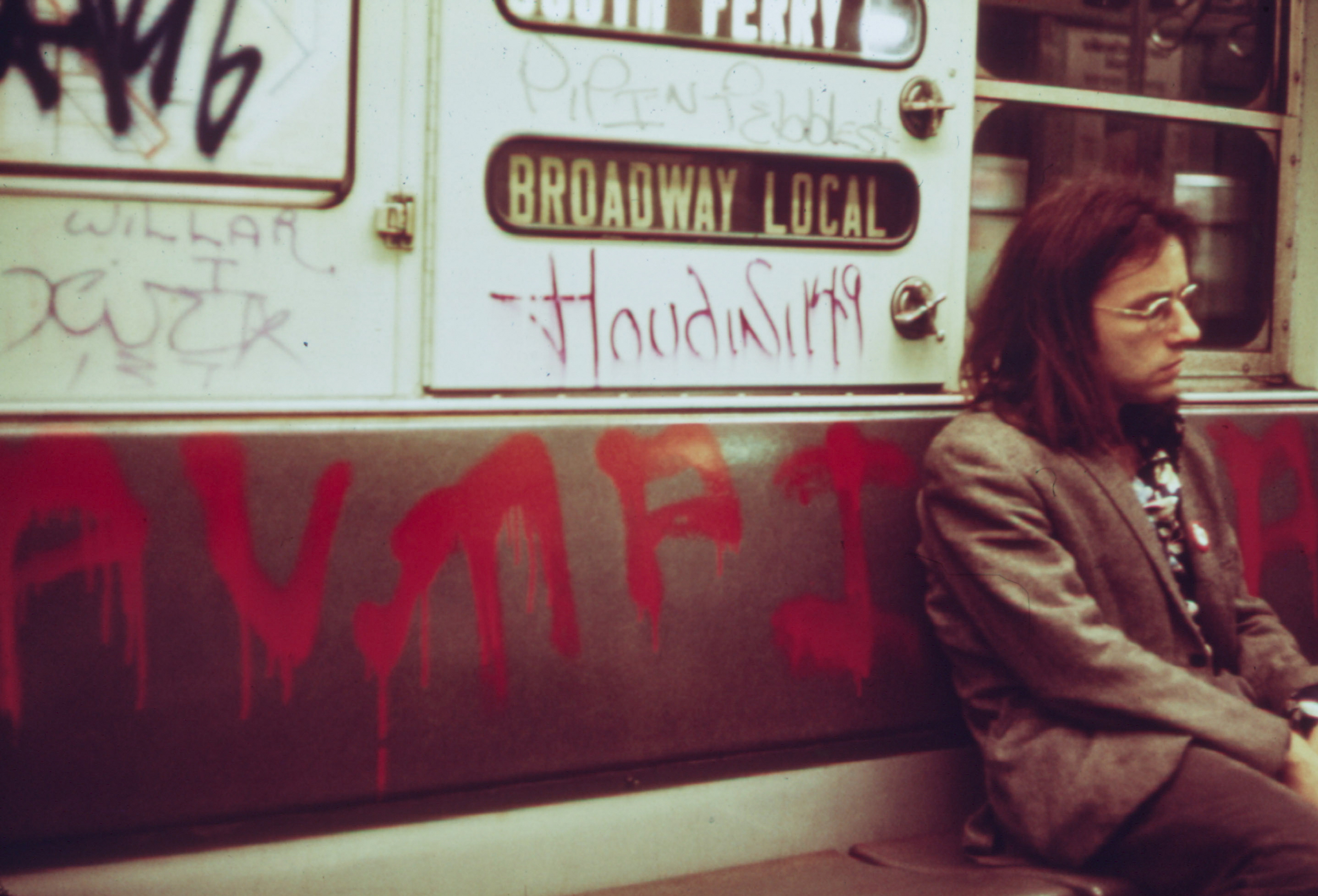 A man with long hair on a subway car extensively marked with graffiti in May 1973. | Source: Getty Images