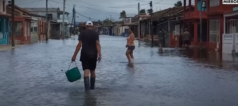 People walking in a flooded area posted on November 18, 2024 | Source: YouTube/@mirrornow