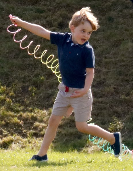 El Príncipe George de Cambridge juega con un juguete Slinky mientras asiste al Trofeo de Polo Maserati Royal Charity en el Club de Polo Beaufort el 10 de junio de 2018. | Fuente: Getty Images El Príncipe George de Cambridge juega con un juguete Slinky mientras asiste al Trofeo de Polo Maserati Royal Charity en el Club de Polo Beaufort el 10 de junio de 2018. | Fuente: Getty Images