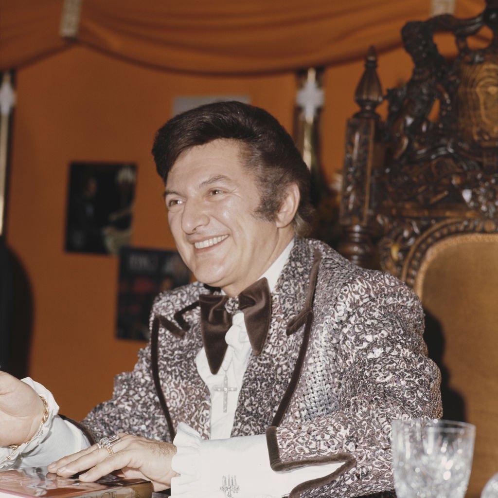 pianist and singer Liberace (1919 - 1987) signs copies of his book in Selfridges, London | Getty Images