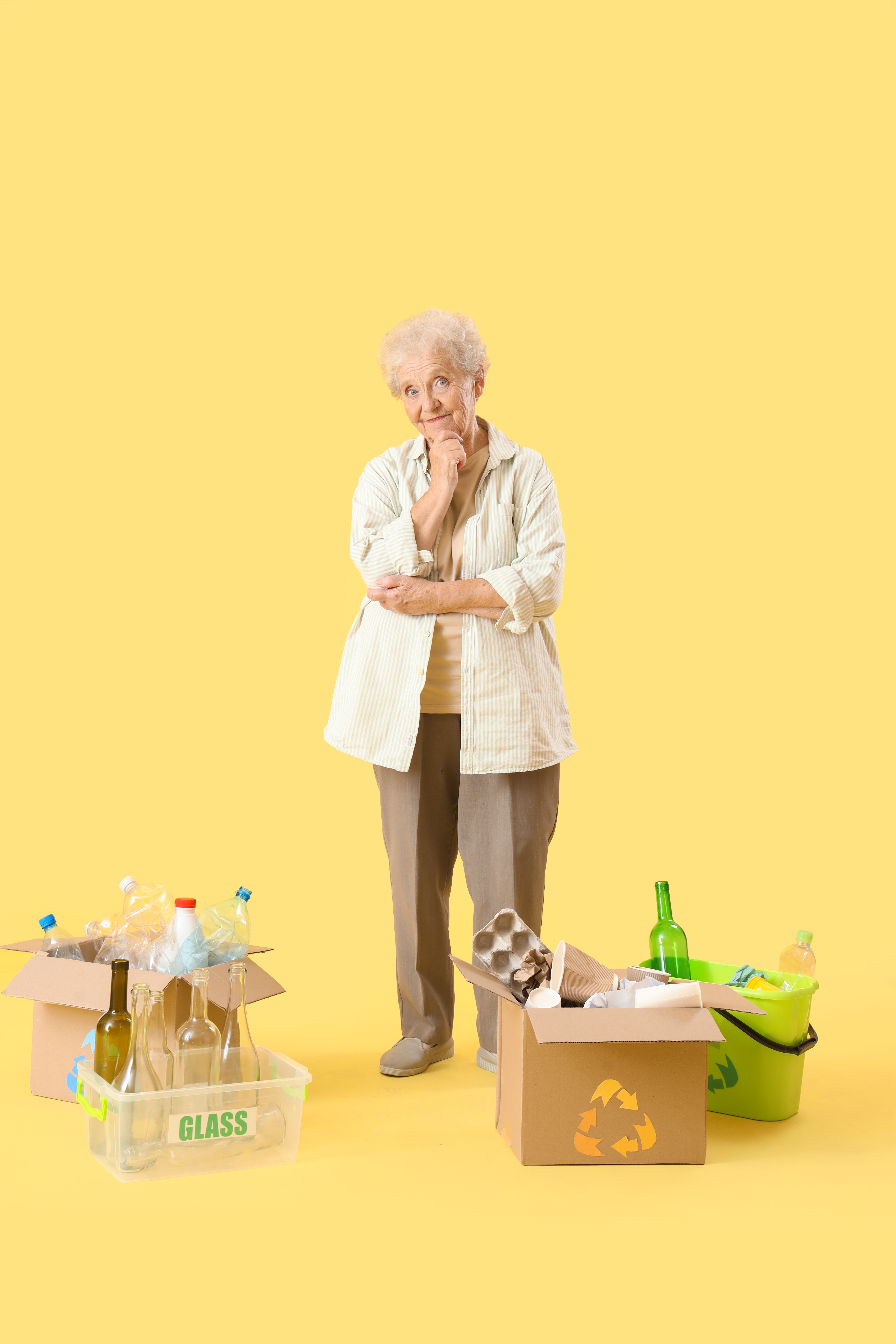 A senior woman standing amid boxes with an assortment of home items inside | Source: Shutterstock