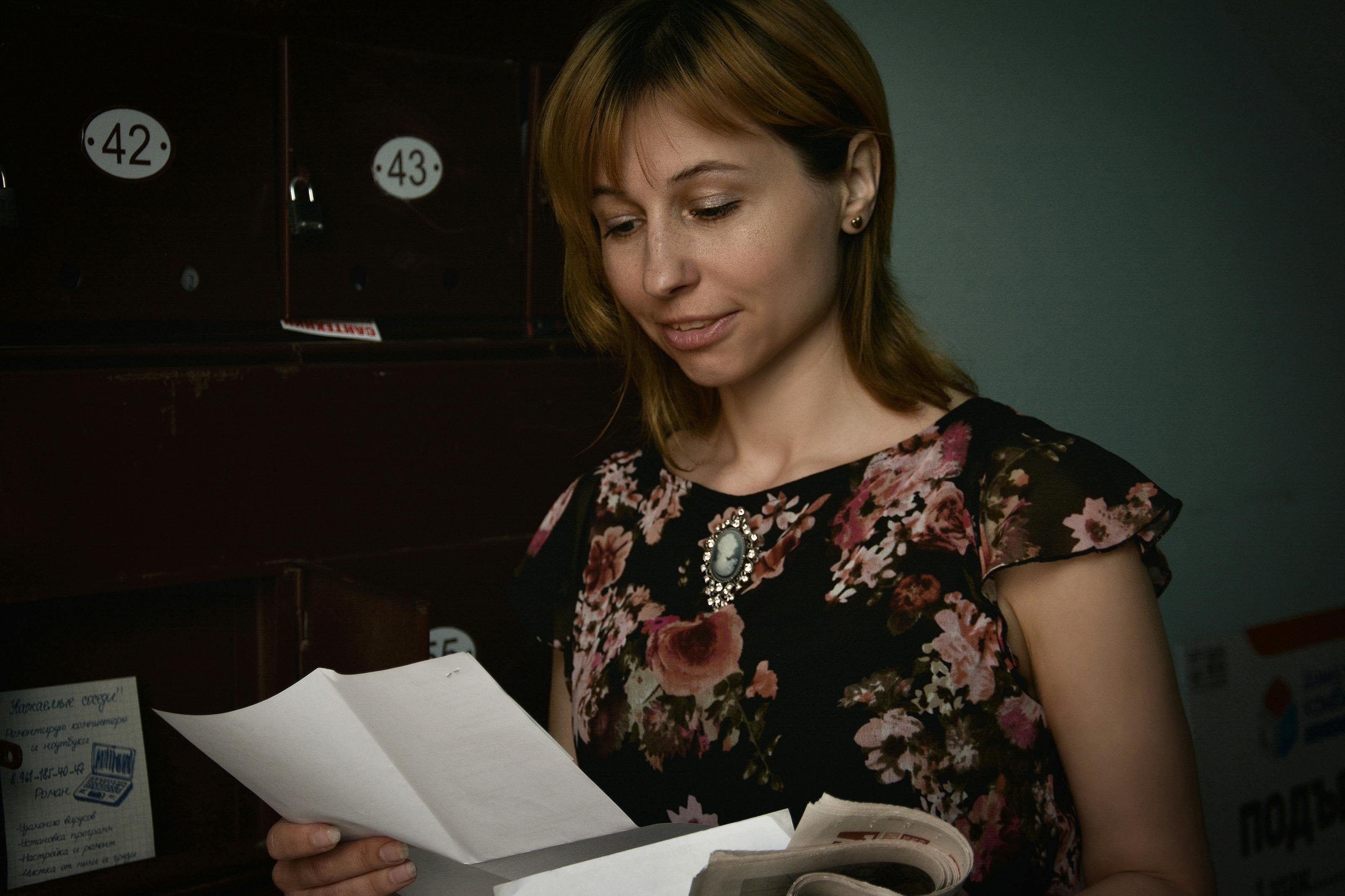 A woman standing and reading a letter | Source: Pexels