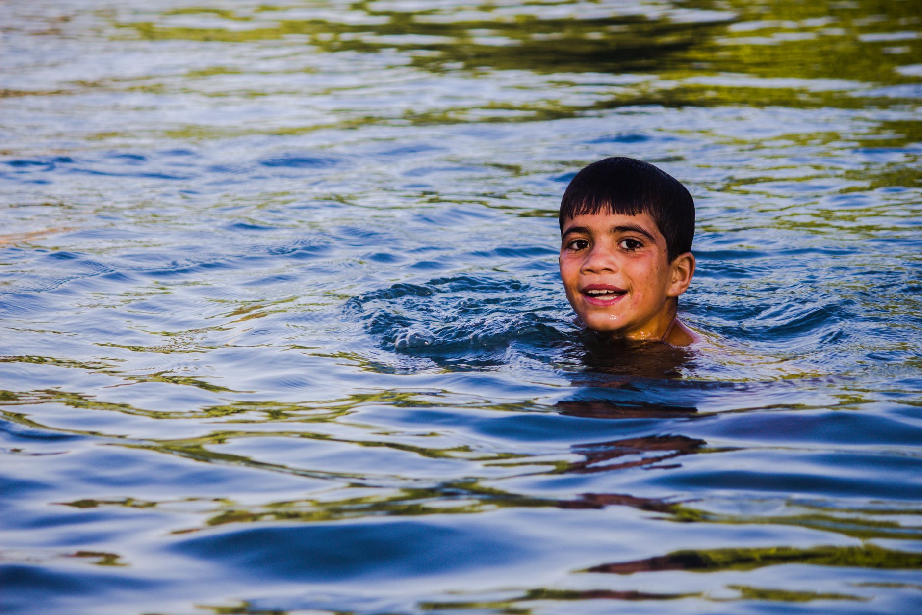 Niño nadando en un lago. | Foto: Pexels