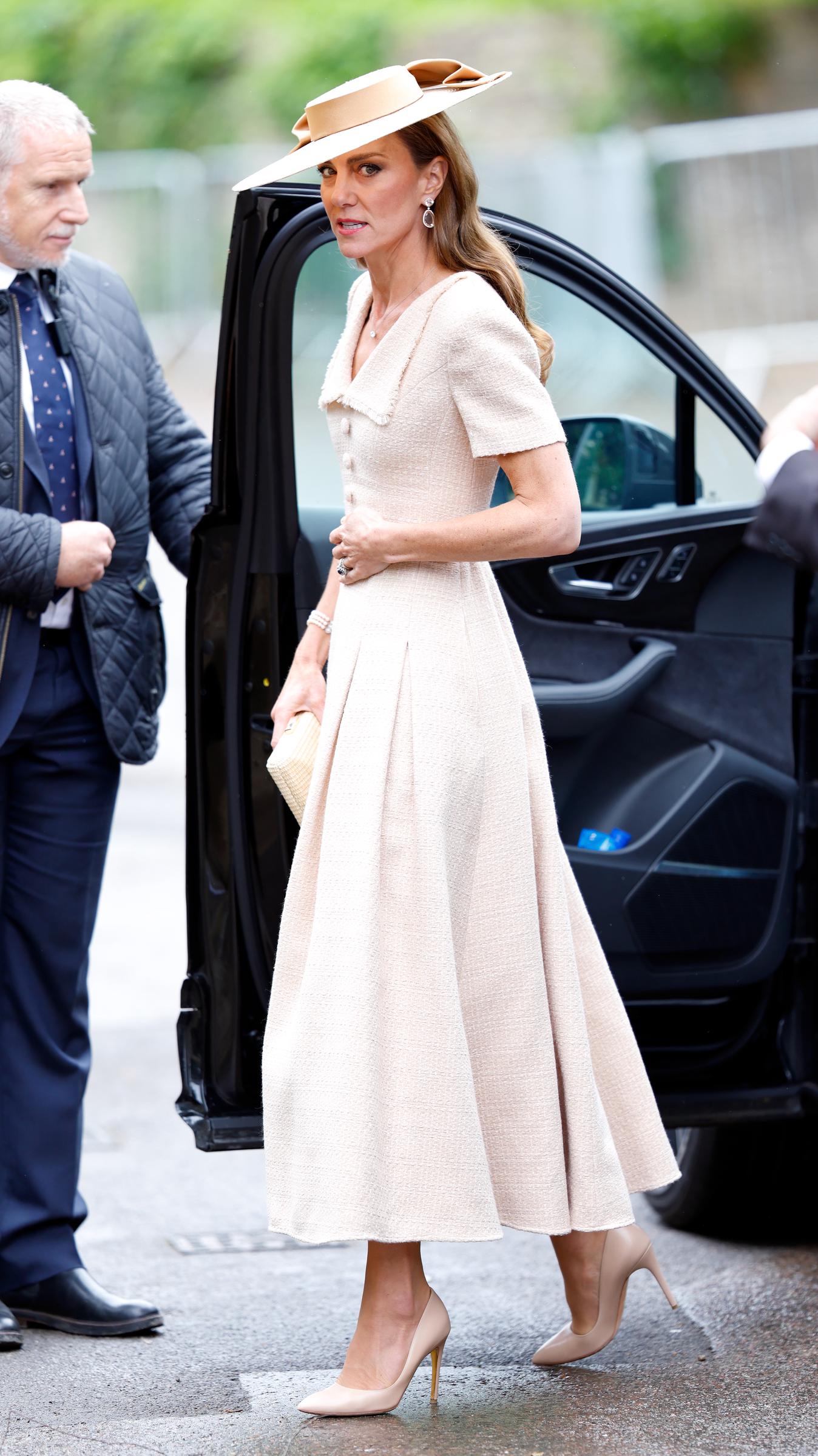 Catherine is photographed arriving at the wedding venue, offering a full view of her textured cream midi dress, coordinated accessories, and wide-brimmed statement hat. | Source: Getty Images