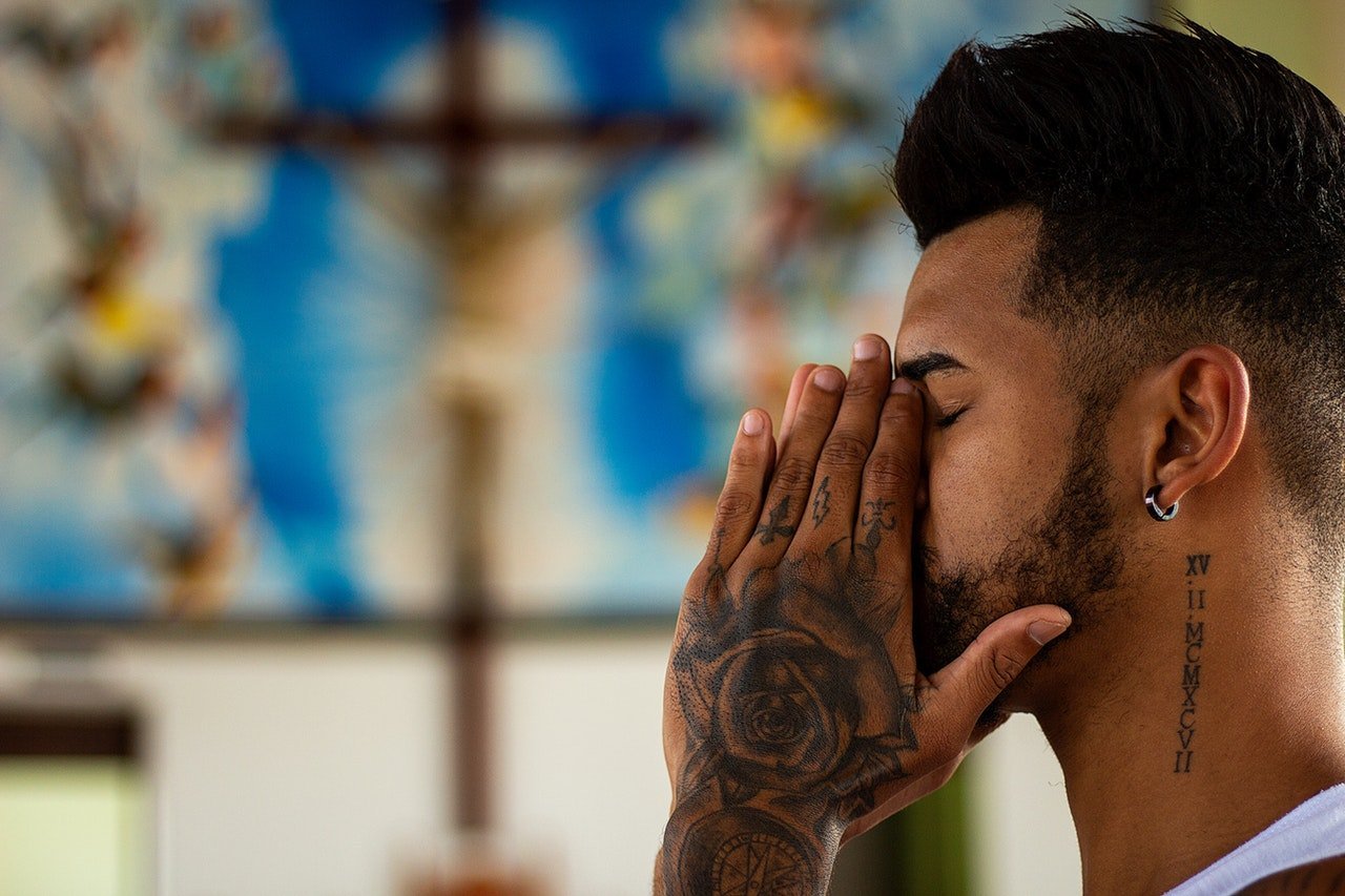 An image showing a man praying in church | Source: Pexels
