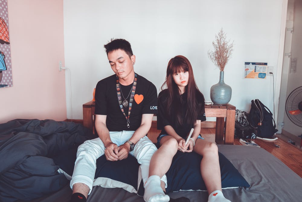 Un couple assis côte à côte sur le lit. | Photo: Pexels