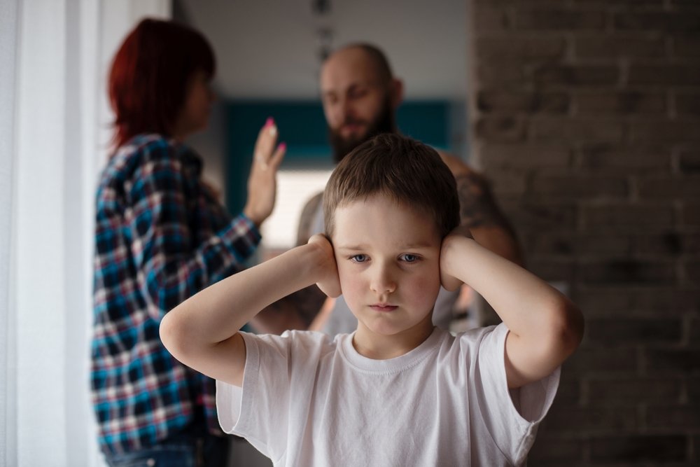 Niño se tapa los oídos mientras sus padres pelean. | Foto: Shutterstock