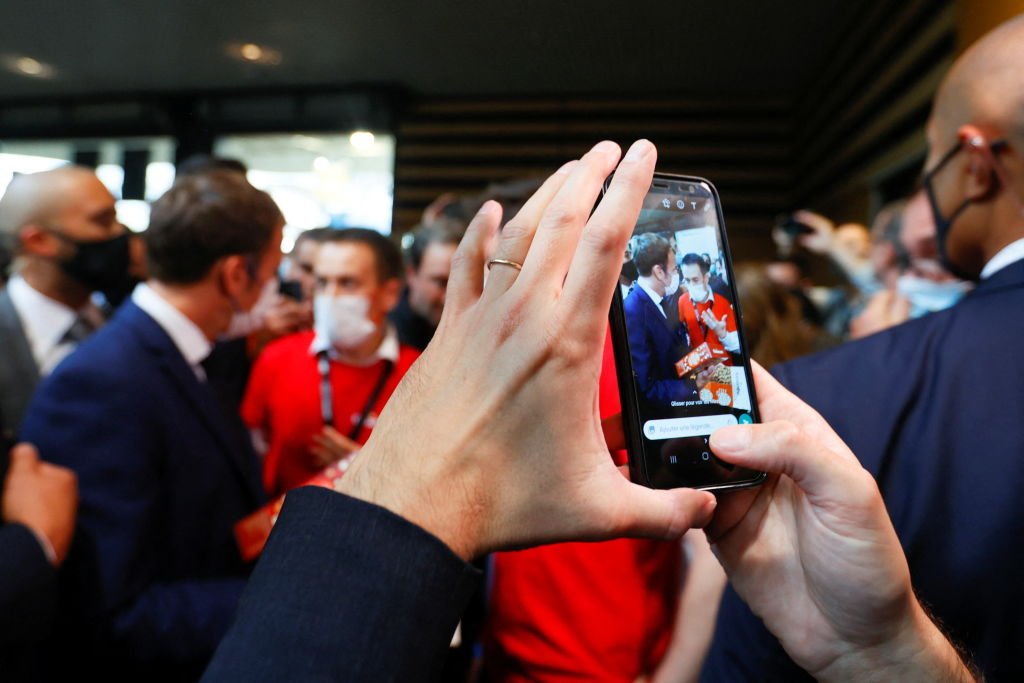 Le président français Emmanuel Macron est vu sur l'écran d'un téléphone portable.| Photo : Getty Images