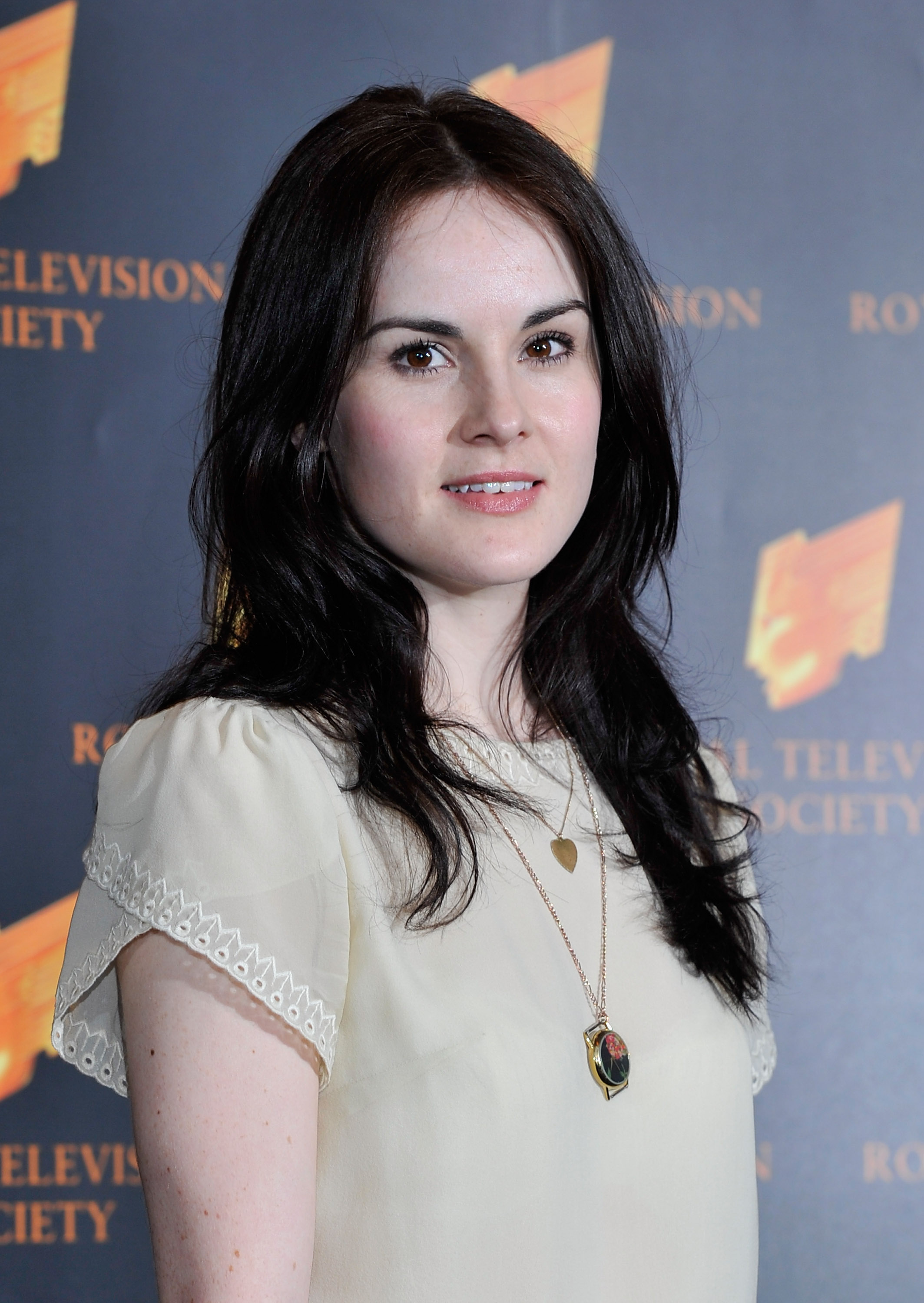 Michelle Dockery attended the RTS Programme Awards in 2011 with a natural, youthful look. Wearing a soft cream blouse and minimal makeup, she radiated quiet elegance — a fitting mirror to her breakout role as the poised and complex Lady Mary on "Downton Abbey."
