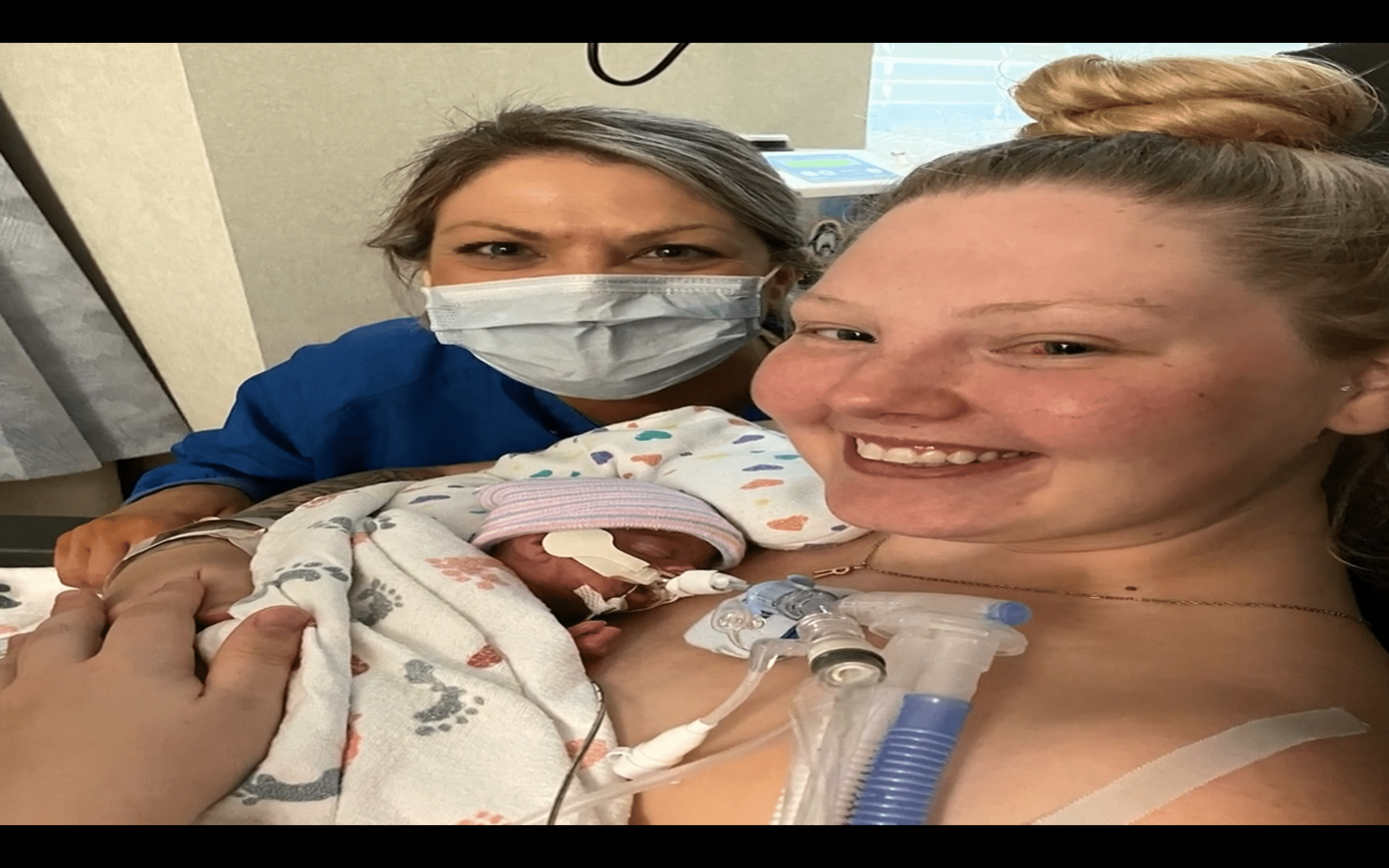 Mom smiling carrying her premature baby with a nurse next to her. | Photo: YouTube/Rizzbag