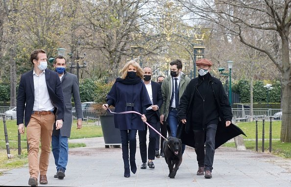 Brigitte Macron, accompagnée de son chien Nemo, se promène avec le dessinateur belge Philippe Geluck. |Photo : Getty Images