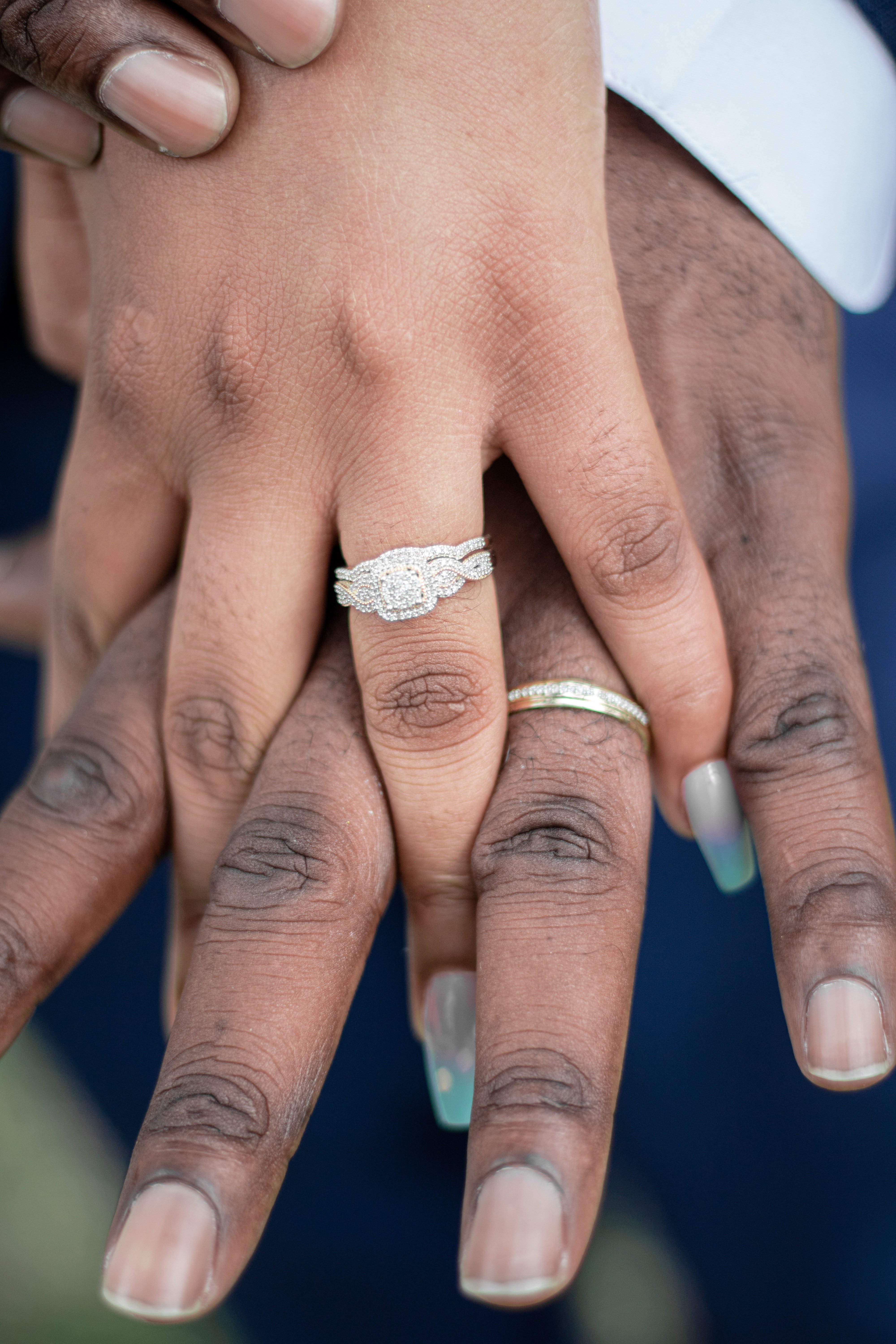 Manos entrelazadas de un hombre y una mujer con anillos nupciales. | Foto: Pexels