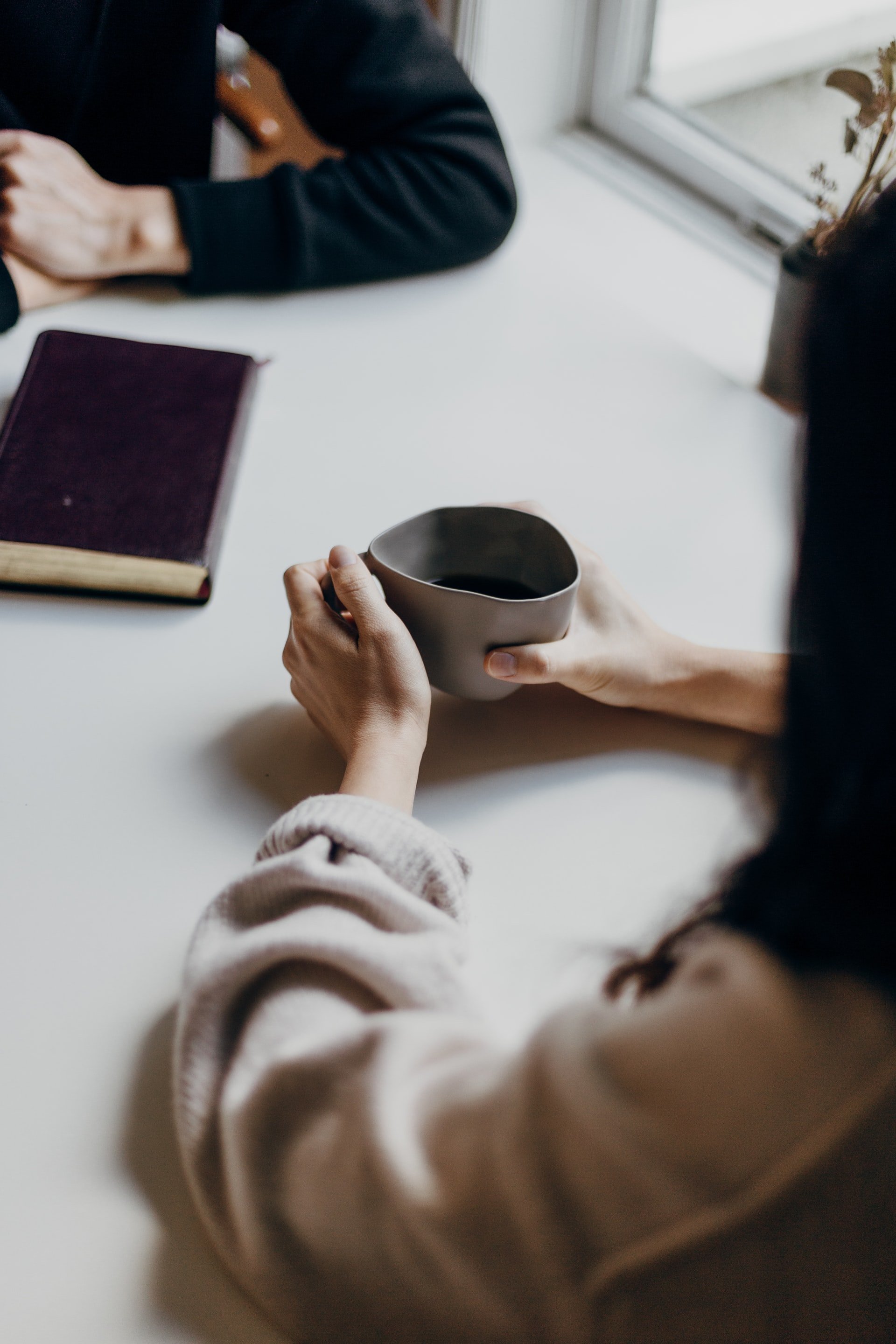 Woman holding coffee mug on table | Source: Unsplash