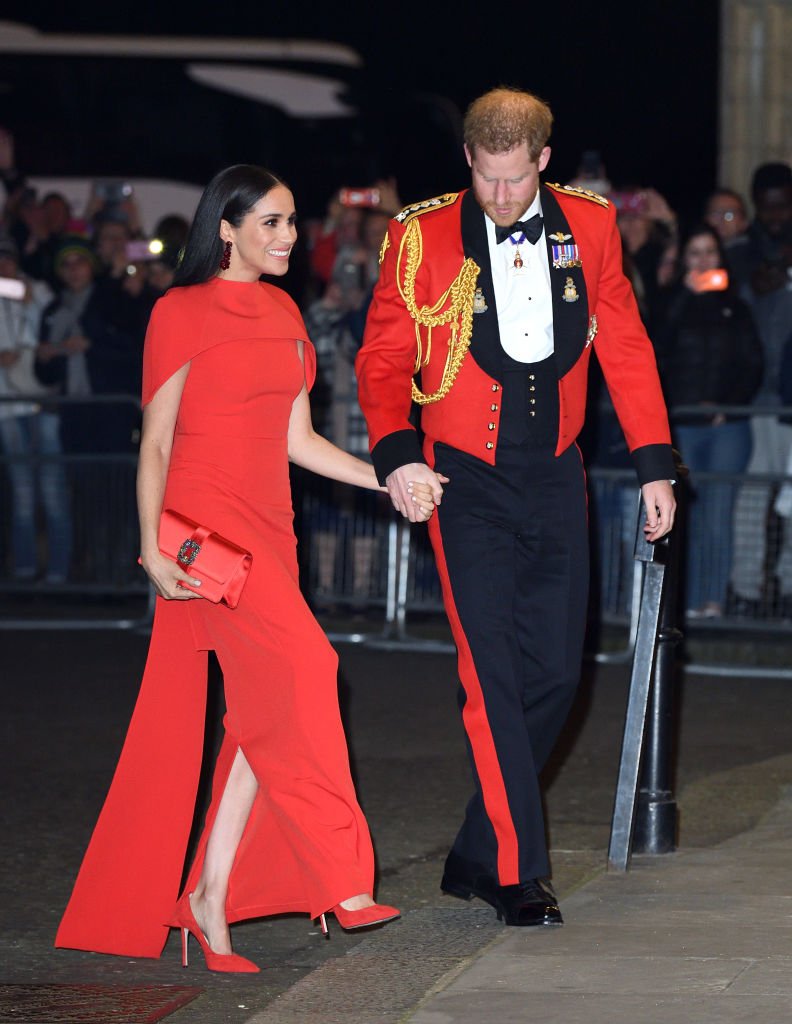 Prince Harry holds Meghan Markle’s hand as he helps up a sidewalk when they arrived at the Mountbatten Festival of Music at Royal Albert Hall on March 07, 2020, in London, England | Source: Getty Images (Photo by Karwai Tang/WireImage)