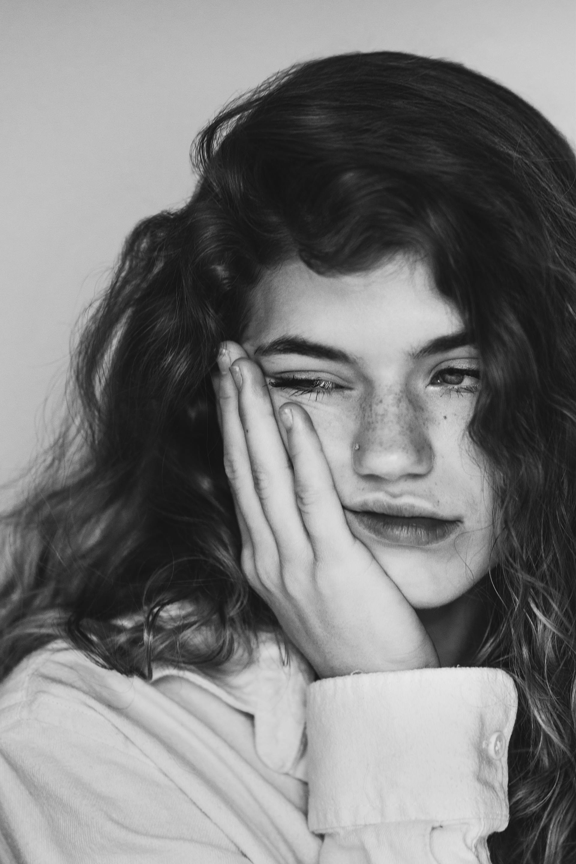 A grayscale photo of a sad woman touching her cheek | Source: Pexels