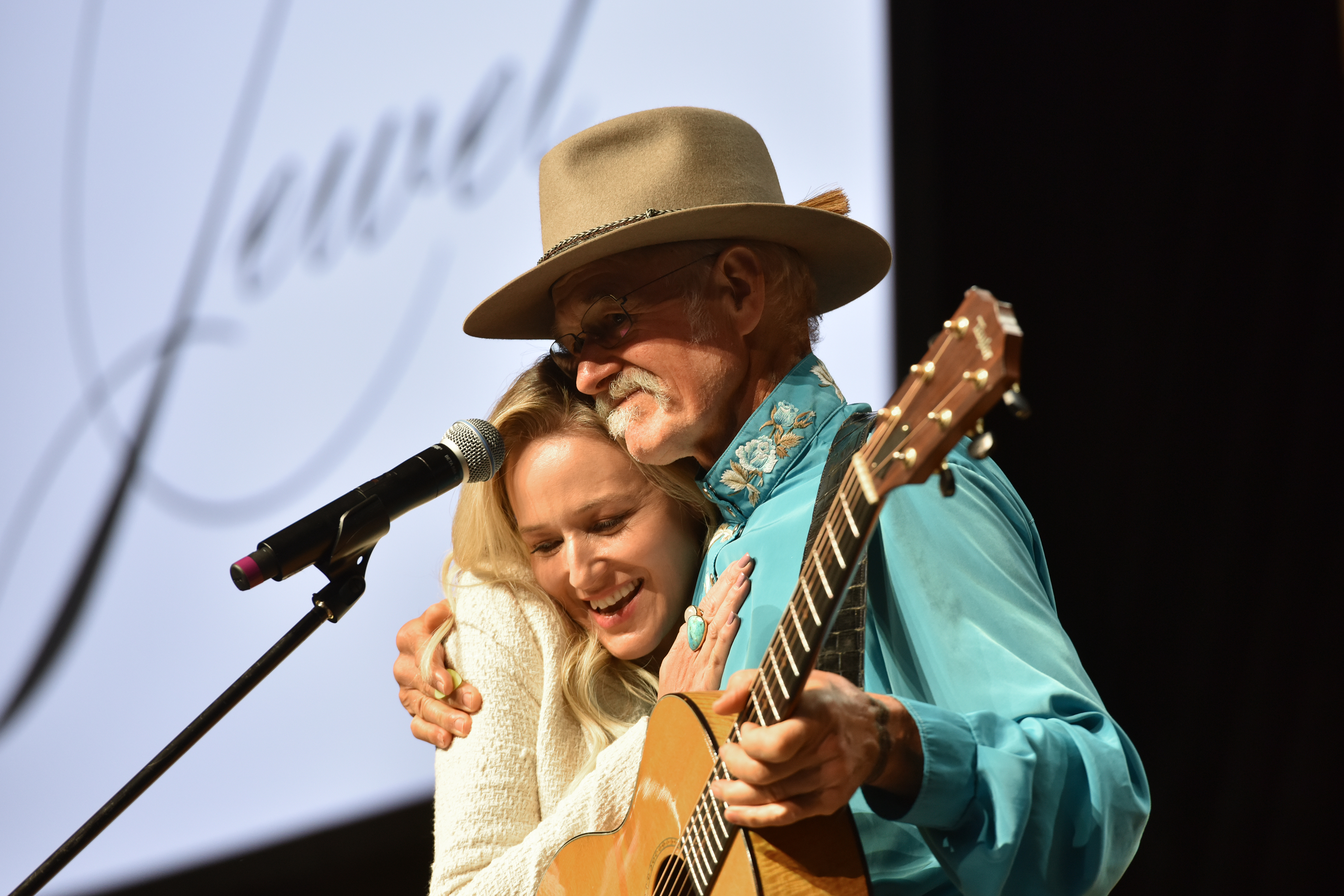 Jewel with her father, Atz Kilcher, on stage during the first day of the Wellness Your Way Festival in Denver, Colorado, on August 16, 2019. | Source: Getty Images