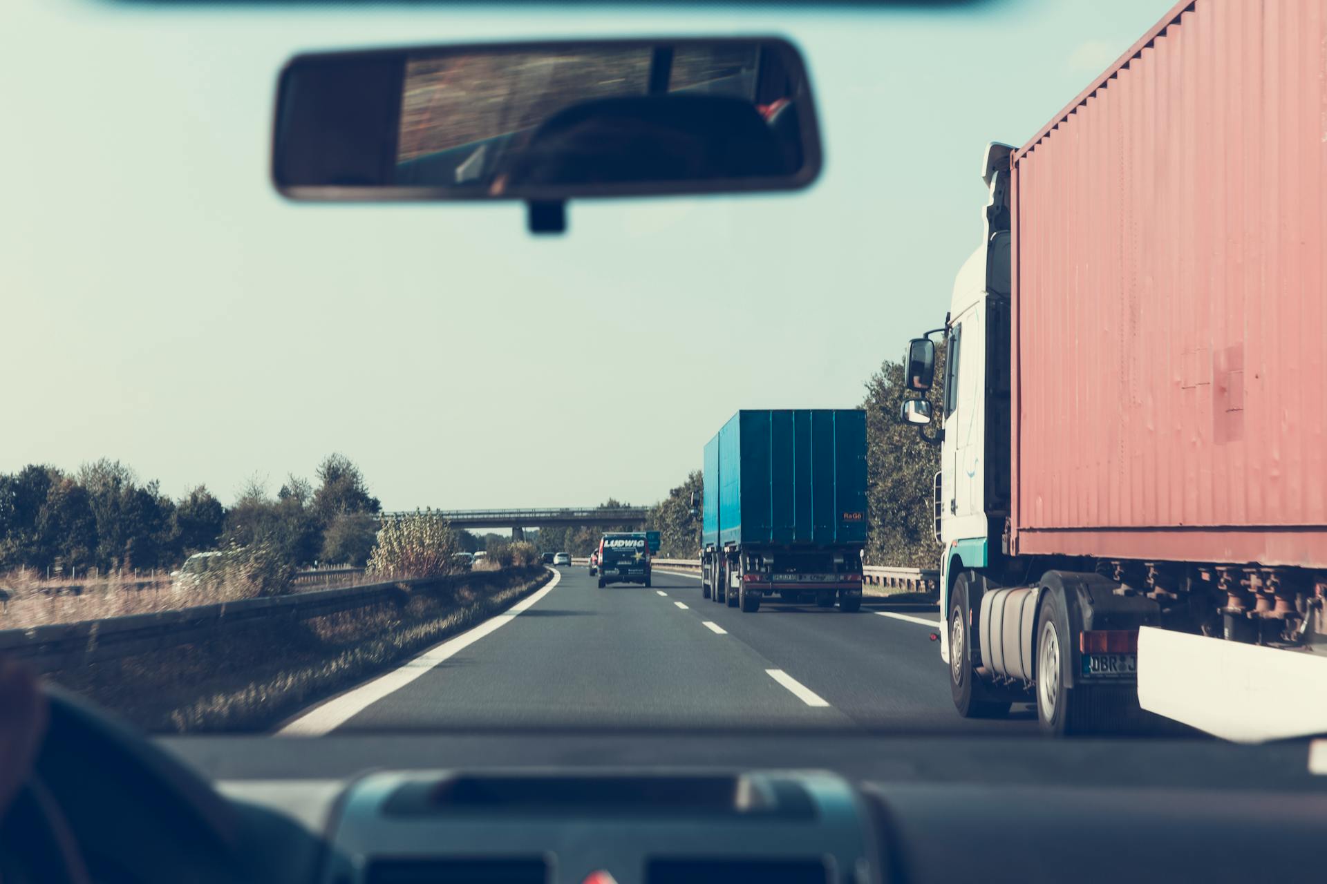 Blue and red freight trucks on a highway | Source: Pexels