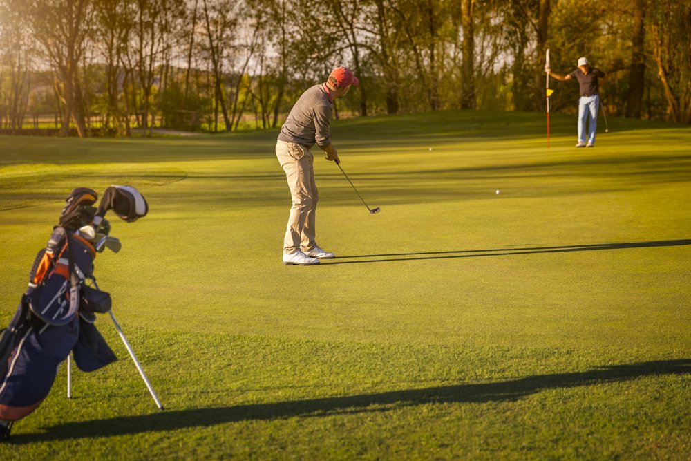 A photo of two people playing golf | Photo: Shutterstock