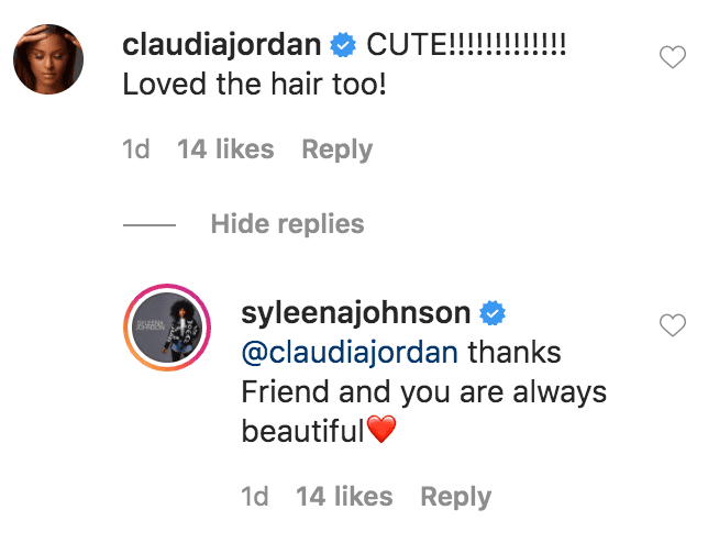Claudia Jordan commented on a photo of Syleena Johnson posing in her living room while dressed in a white maxi-dress | Source: Instagram.com/syleenajohnson