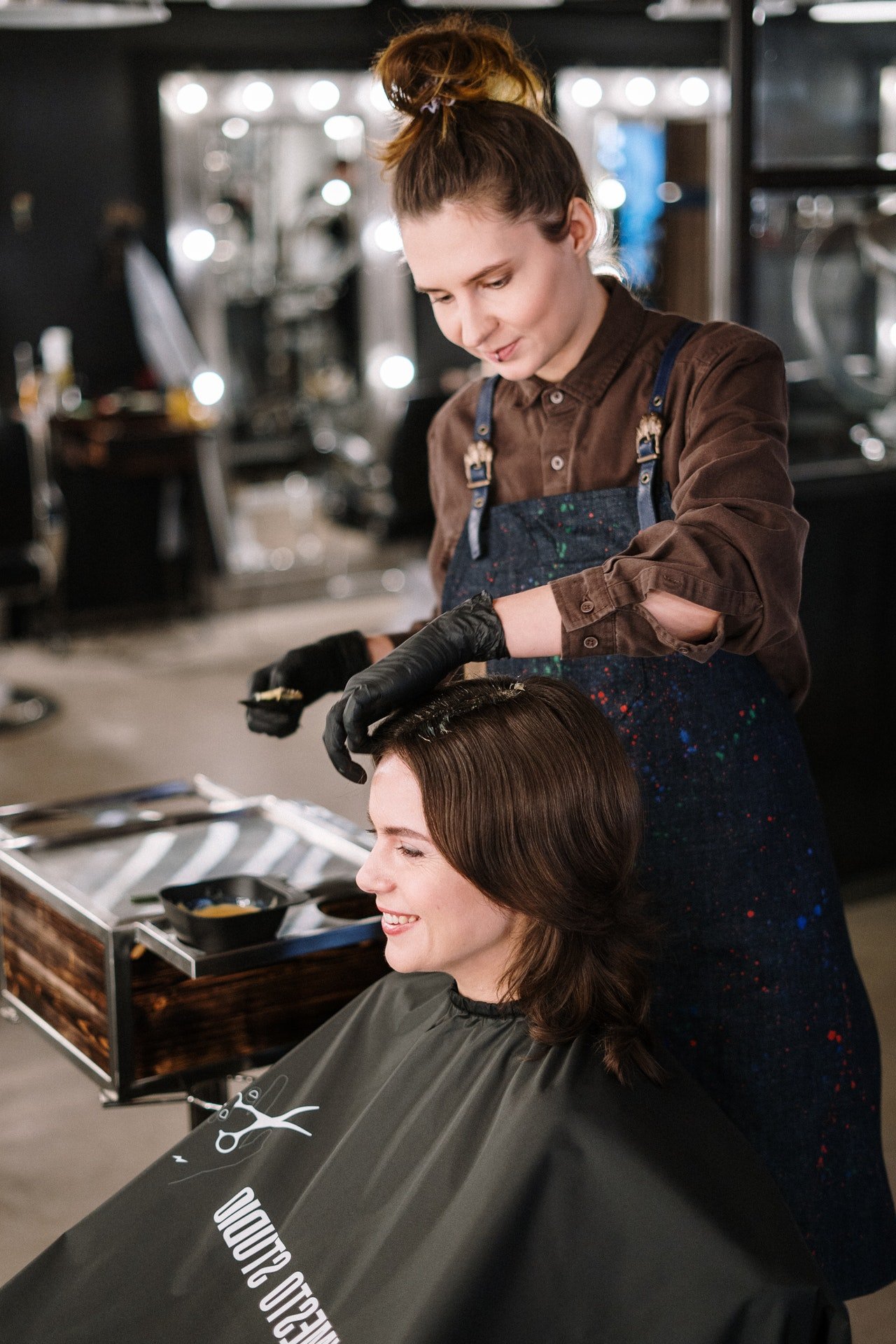 Hairdresser working on woman's hair | Photo: Pexels