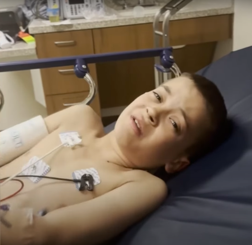 Liam Dahlberg writhing in pain from a hospital bed. | Source: YouTube/WTHR