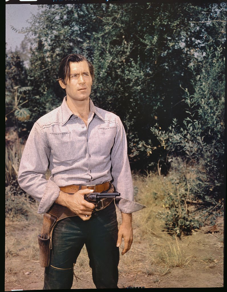 Actor Clint Walker holding a gun on a movie set circa 1962. | Photo: Getty Images