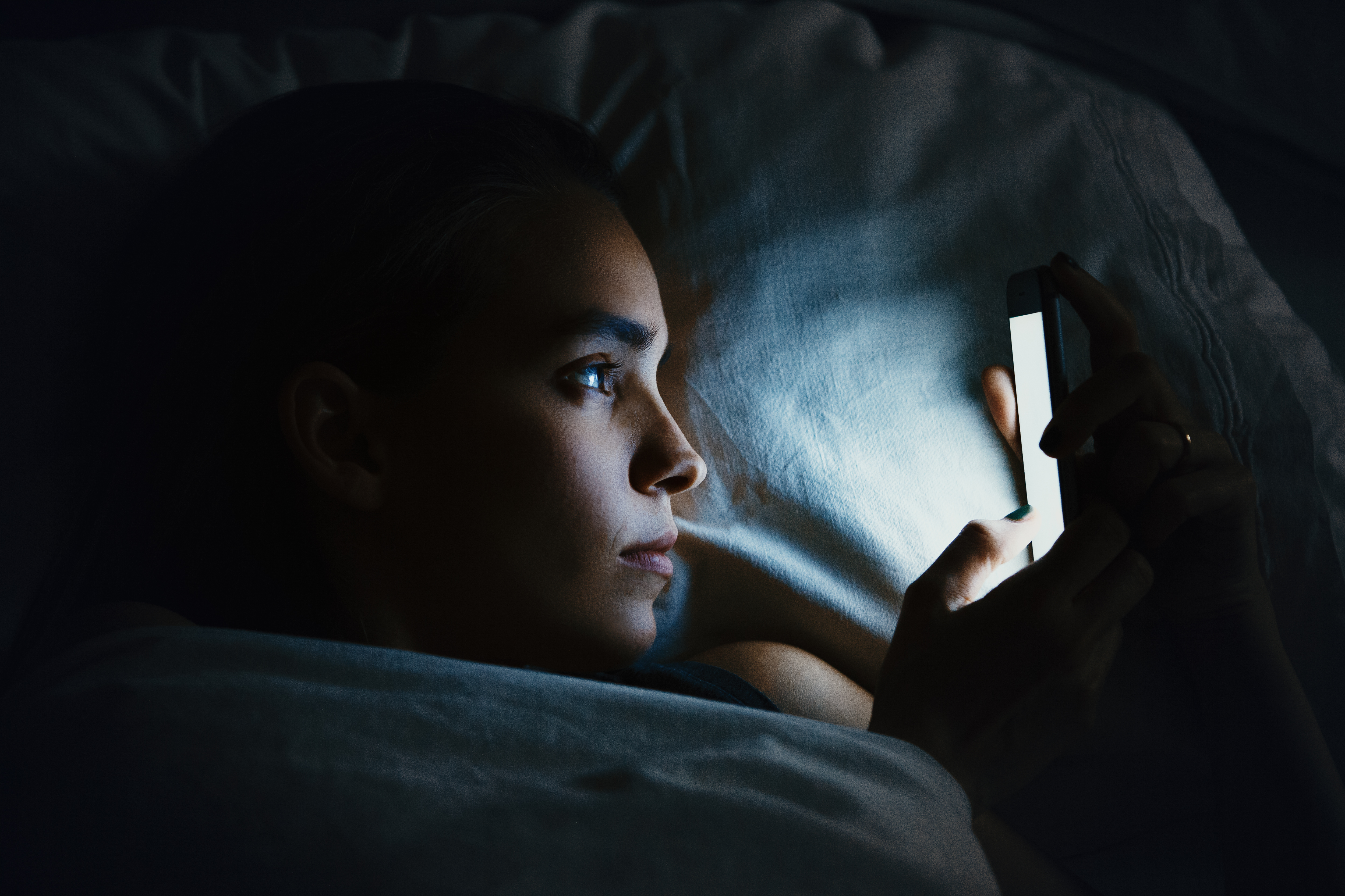 A woman on her phone at night | Source: Shuttertsock