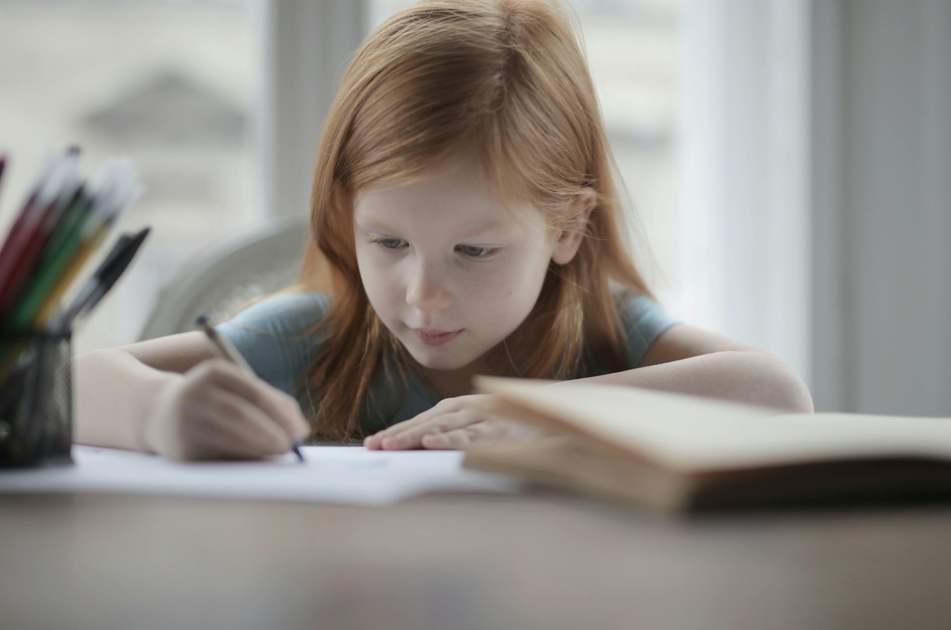 A little girl drawing something on a piece of paper | Source: Pexels